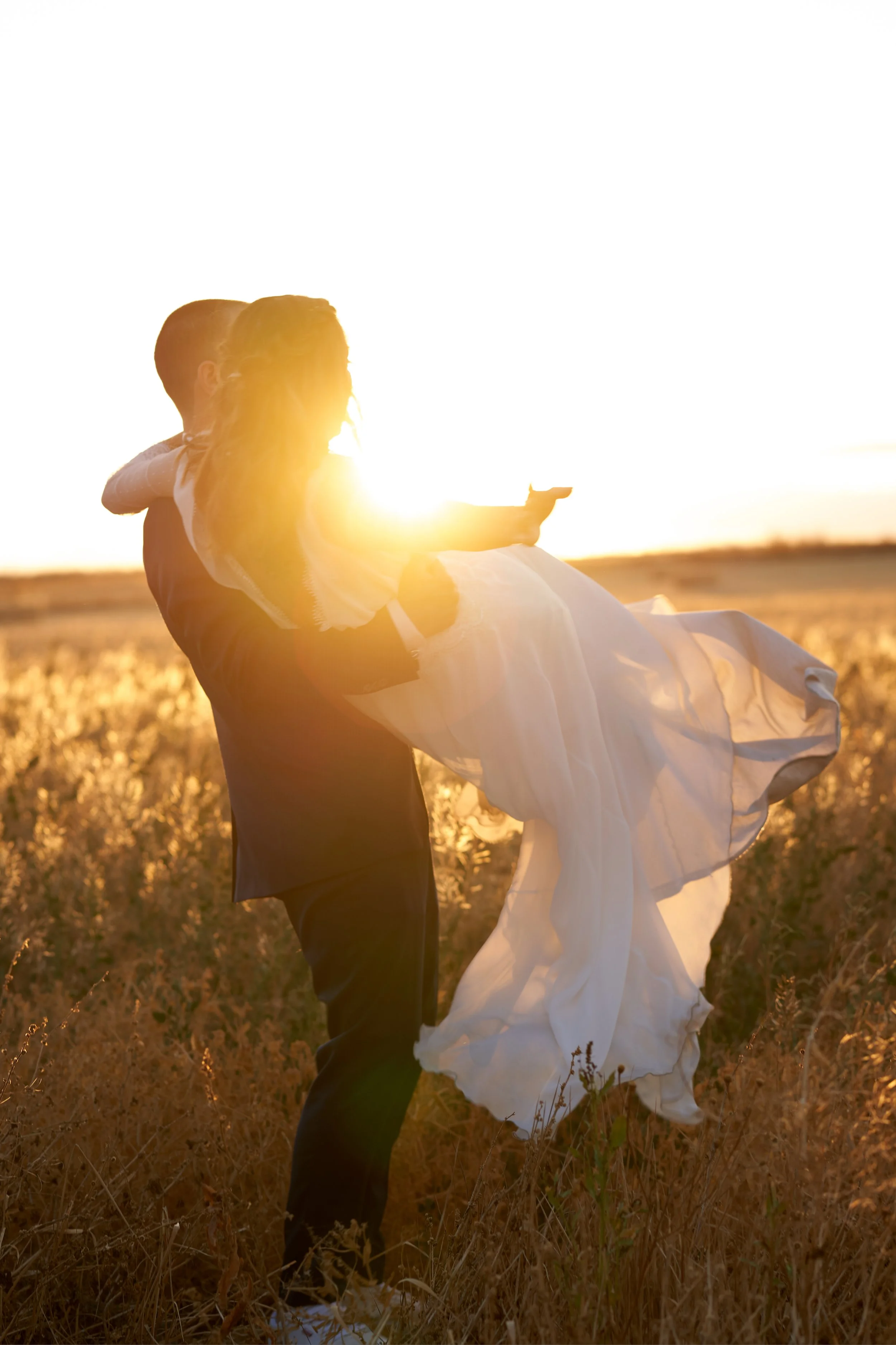 Fernando y Kate, clientes de Laurie, abrazados al lado del lago el día de su boda.