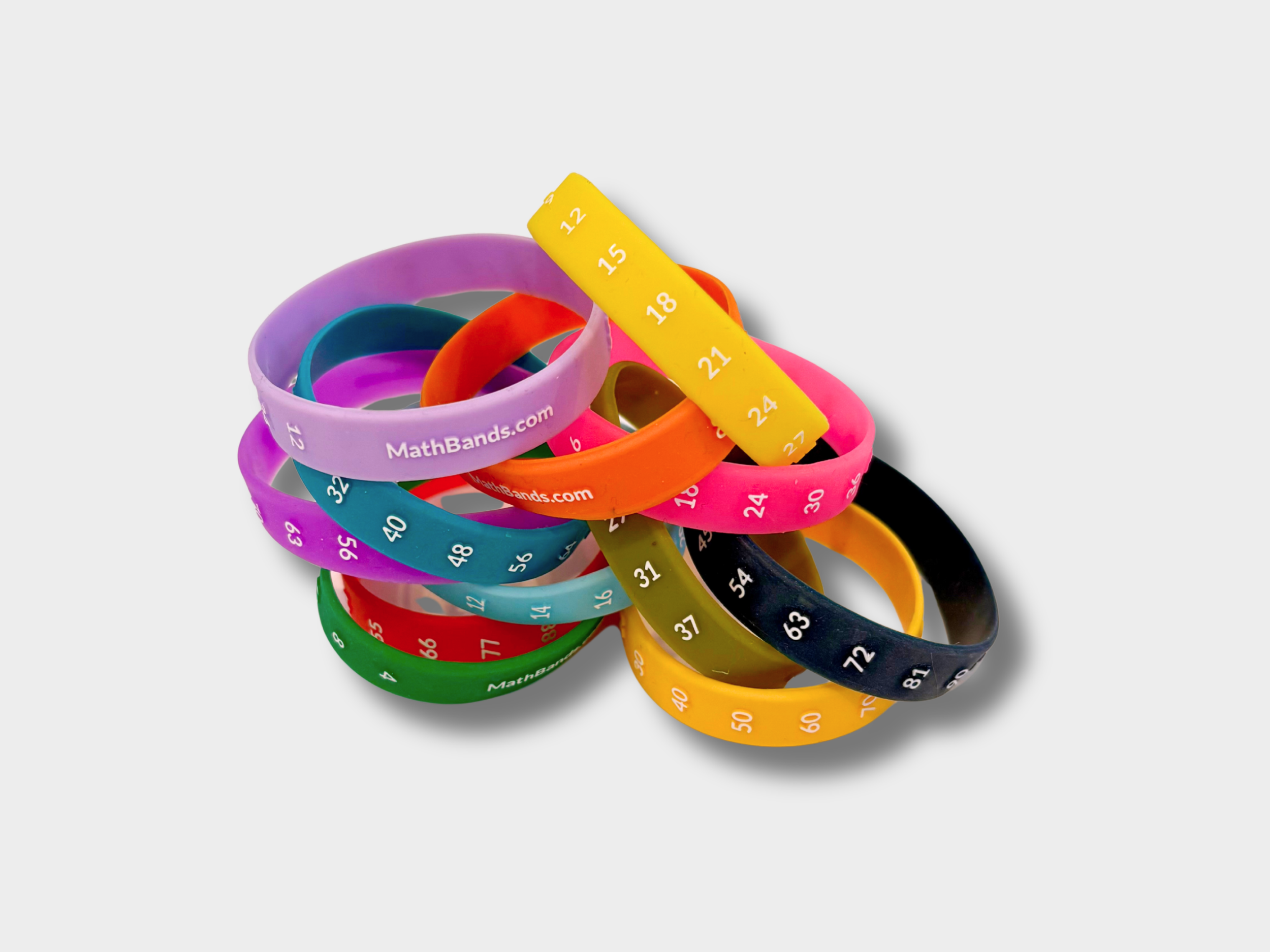 Colorful silicone wristbands as a classroom tool with numbers and text, arranged in a pile on a white background.