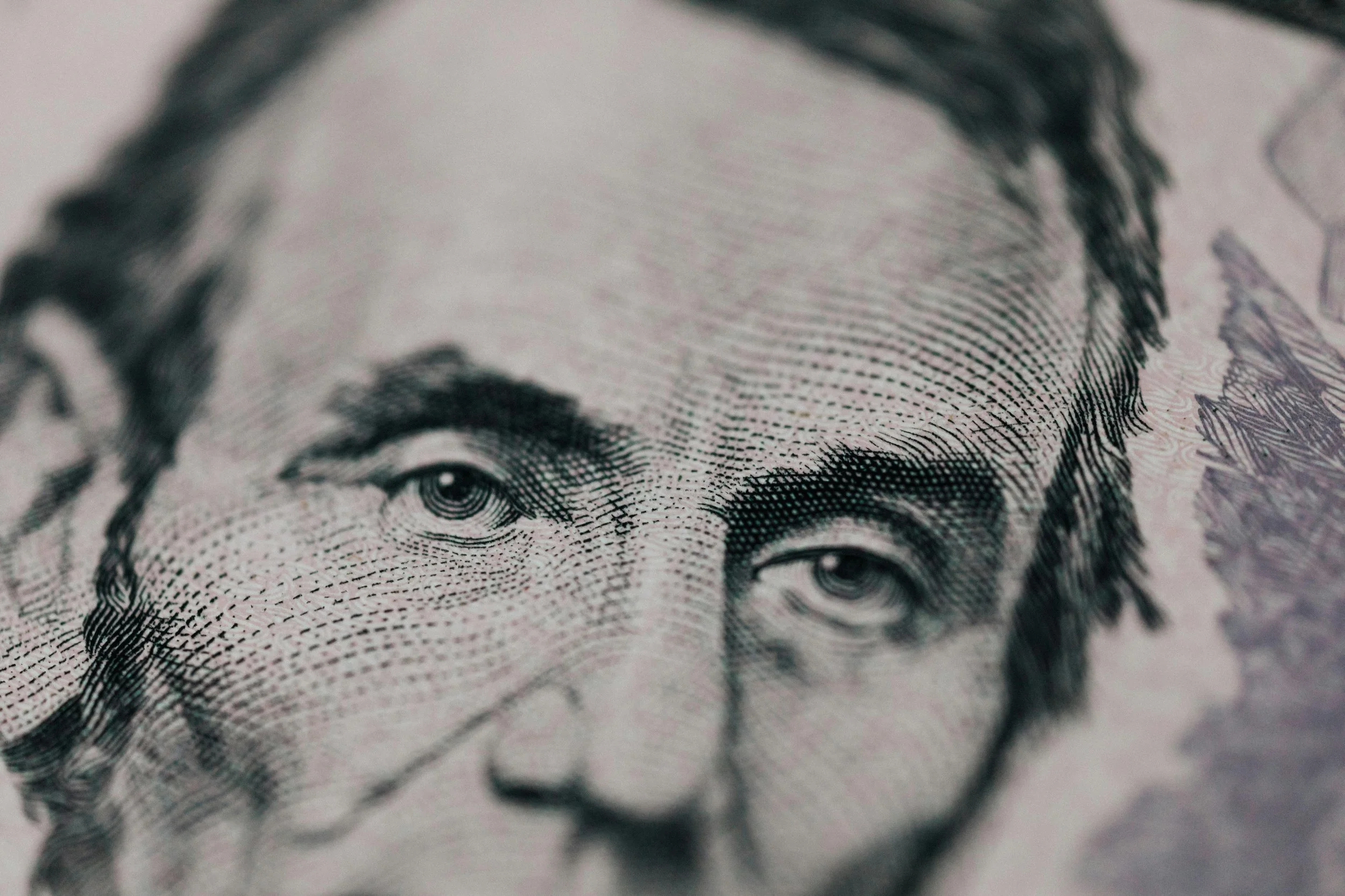 Close-up of Abraham Lincoln's judging eyes on a five dollar bill.
