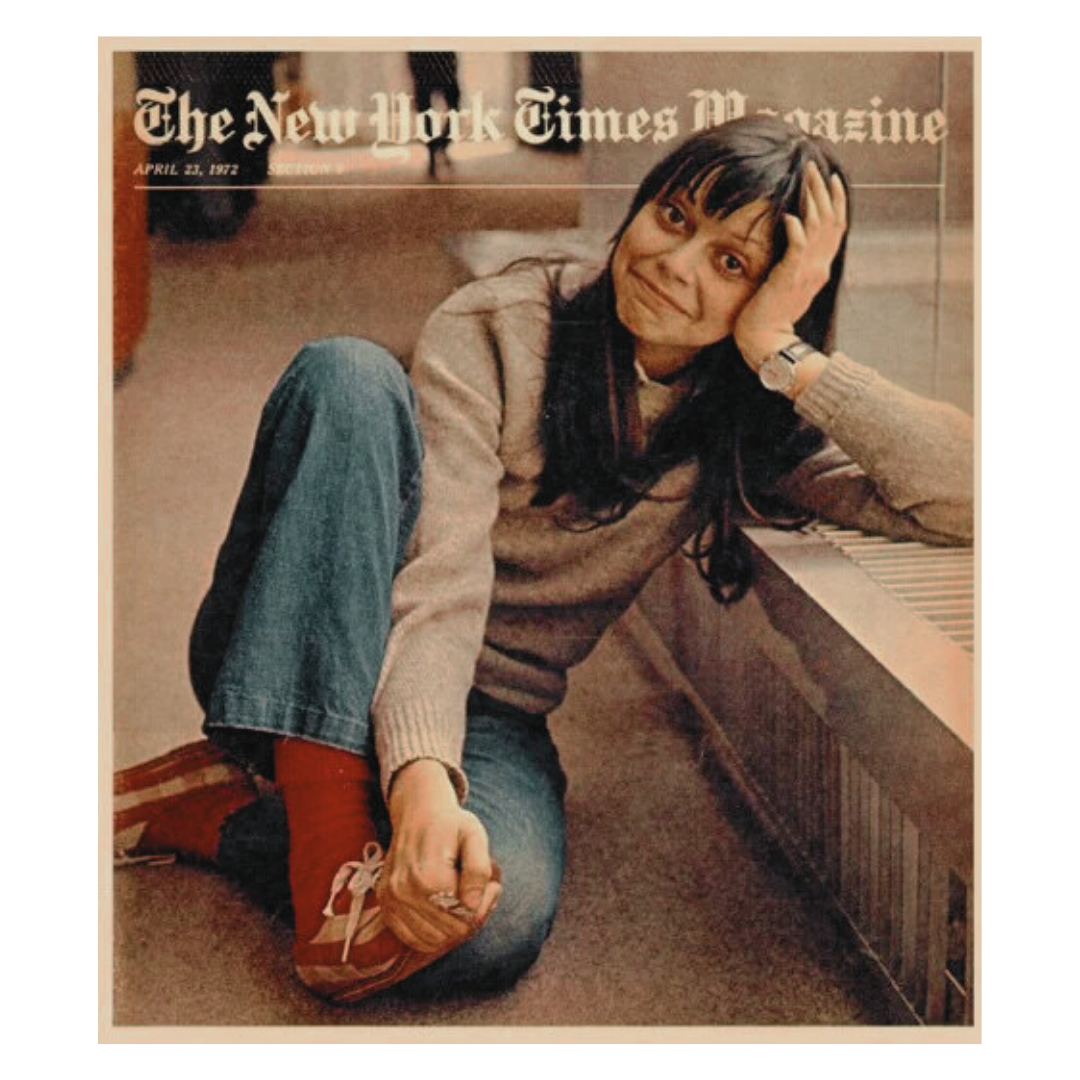 Cover of The New York Times Magazine dated April 23, 1972, featuring a woman with dark hair, wearing a beige sweater, blue jeans, and red shoes, sitting on the floor, holding her right ankle, and smiling at the camera.