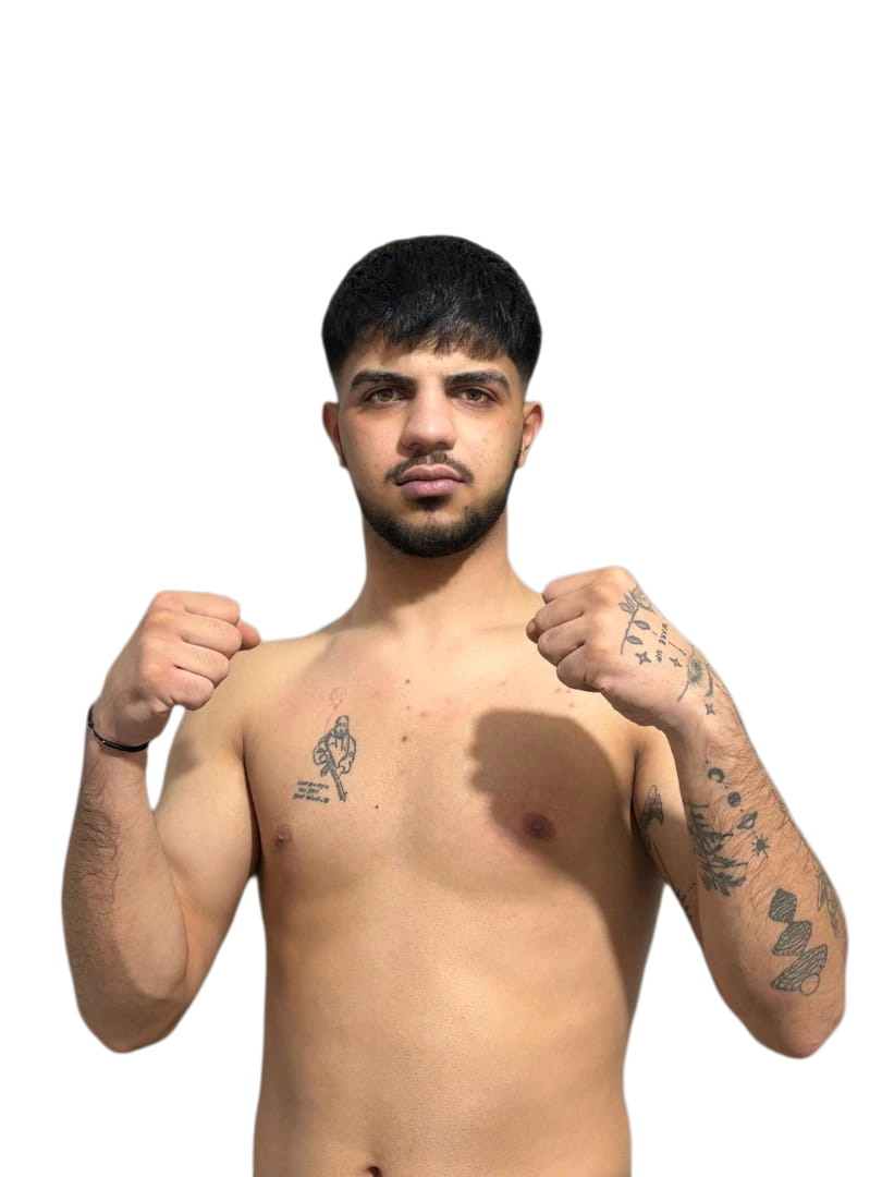 A young man sitting on a beige bench against a beige wall, wearing a gray polo shirt and cream-colored pants, with a shadow cast on the wall
