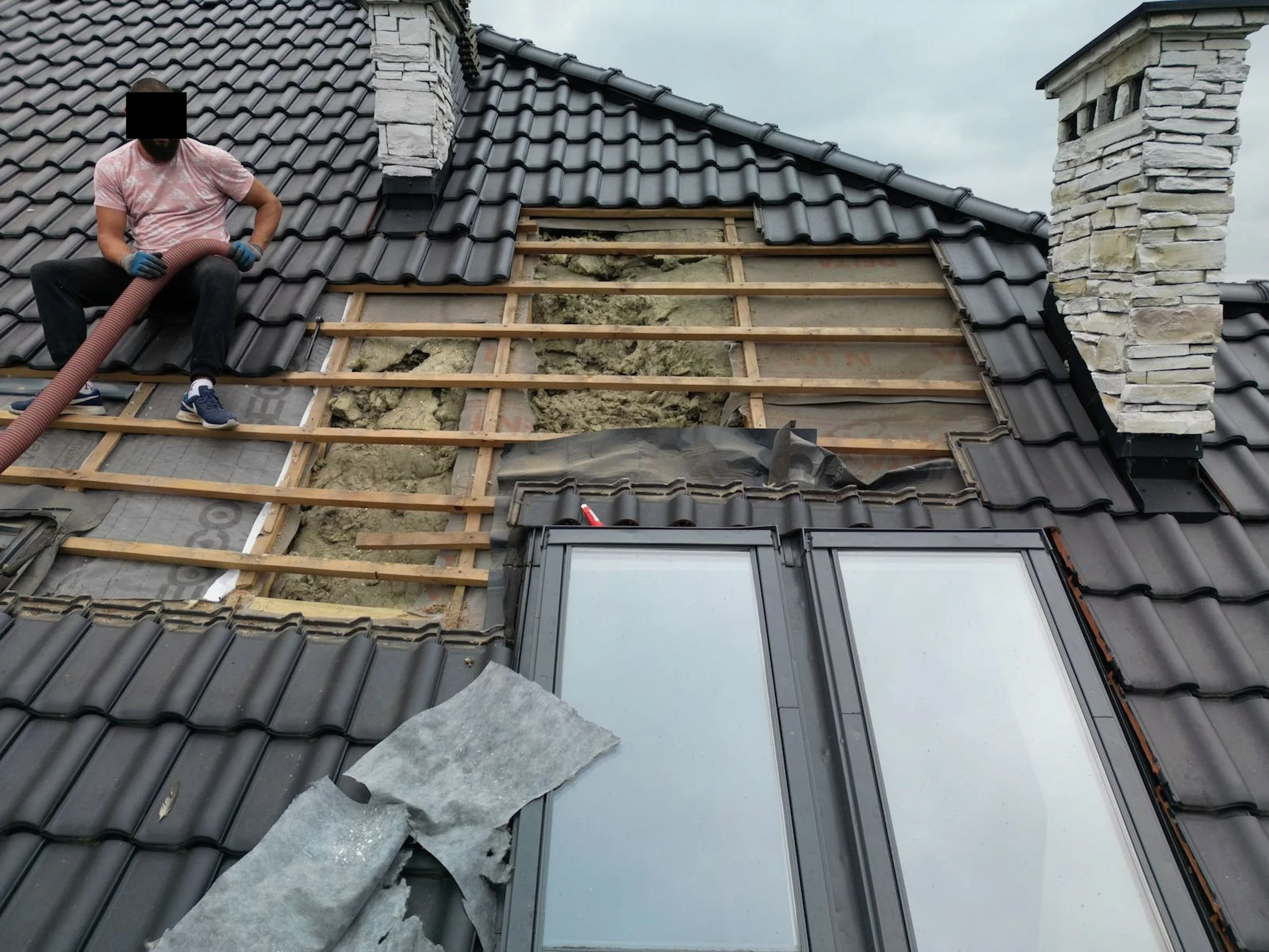 Zobacz jak mocno została dobita izolacja pod folią która jest tak wybrzuszona, że dociska do drewnianych łat (patrz na okolice buta). Tu będzie zbierała się wilgoć niszcząc drewniane elementy dachu (już zniszczyła, ale o tym potem)