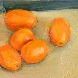 Five oranges on a green surface with a dark background.