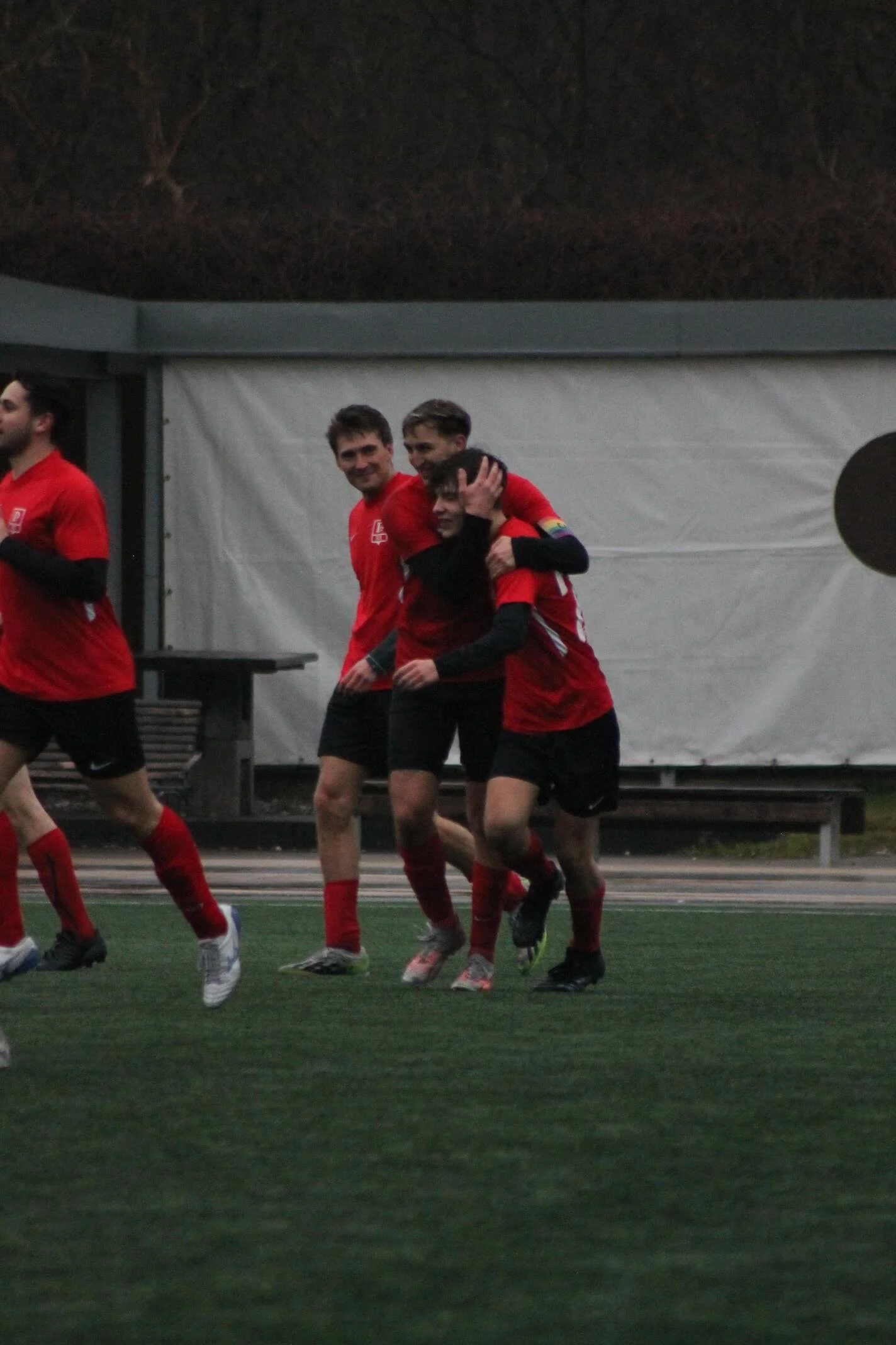 Fußballspieler in roter Trikots feiern auf dem Spielfeld.