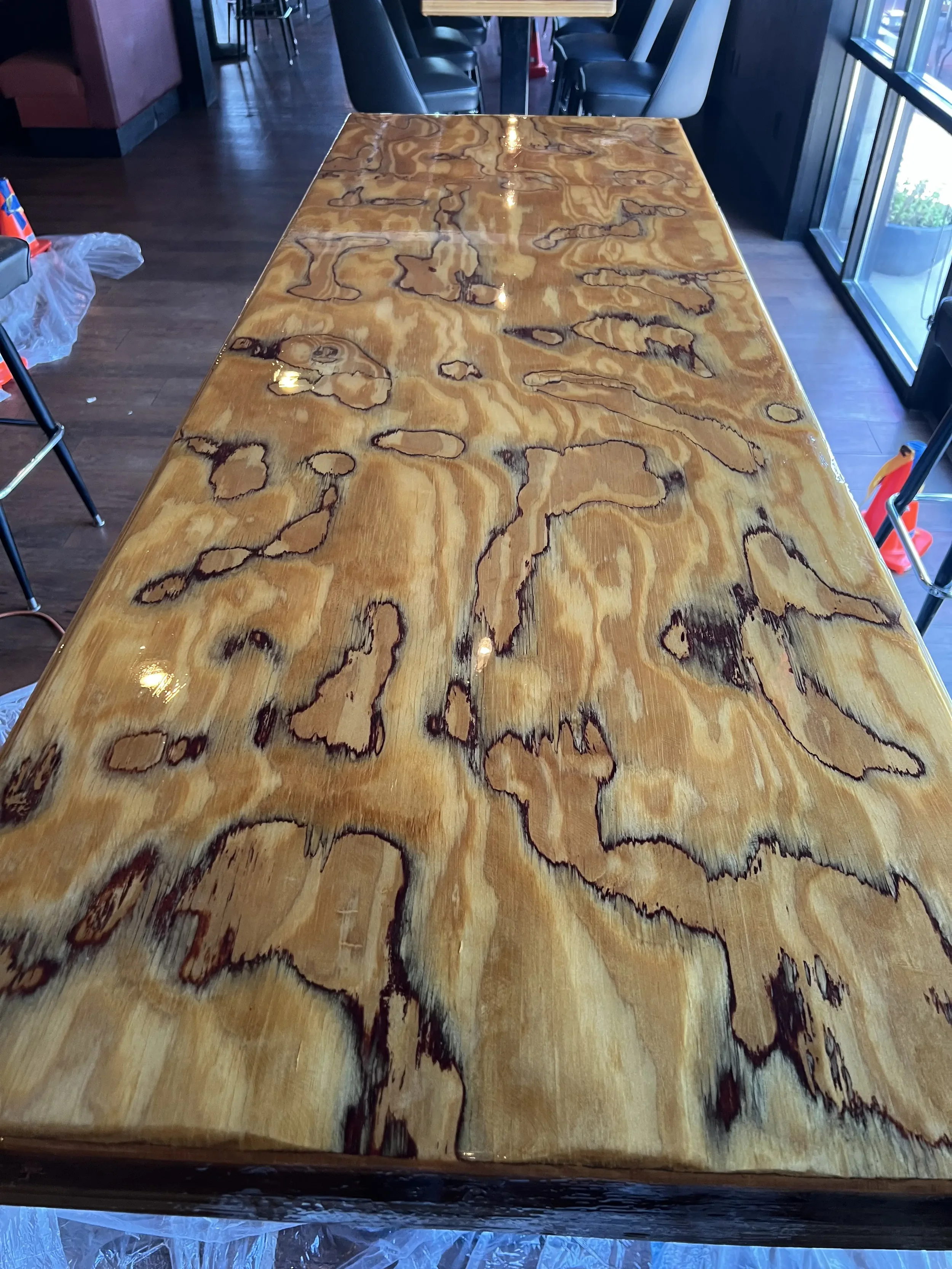 A wooden table with a highly polished surface, showing natural wood grain patterns.