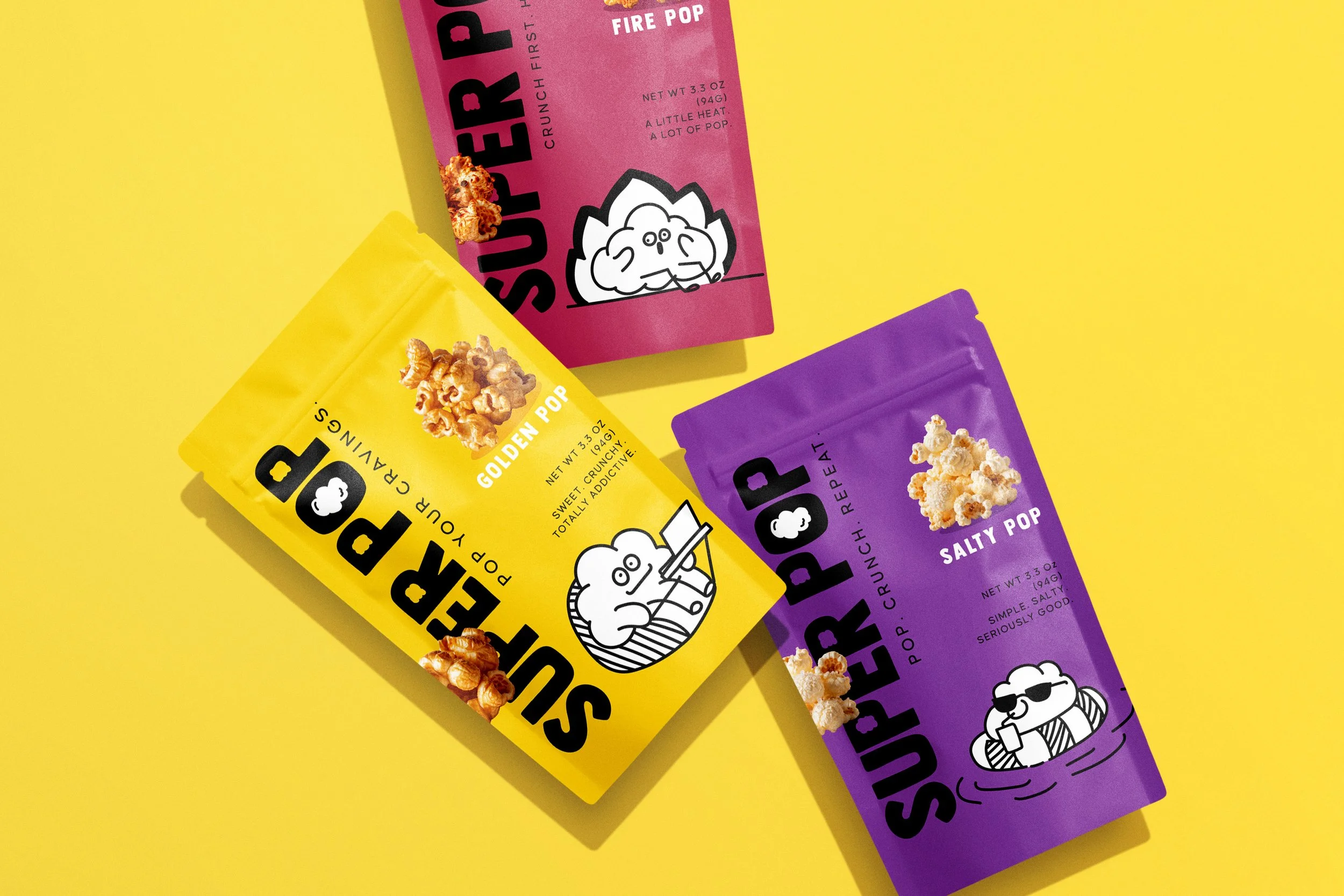 Colorful popcorn snack bags in purple, yellow, and pink with cartoon popcorn characters on a yellow background.