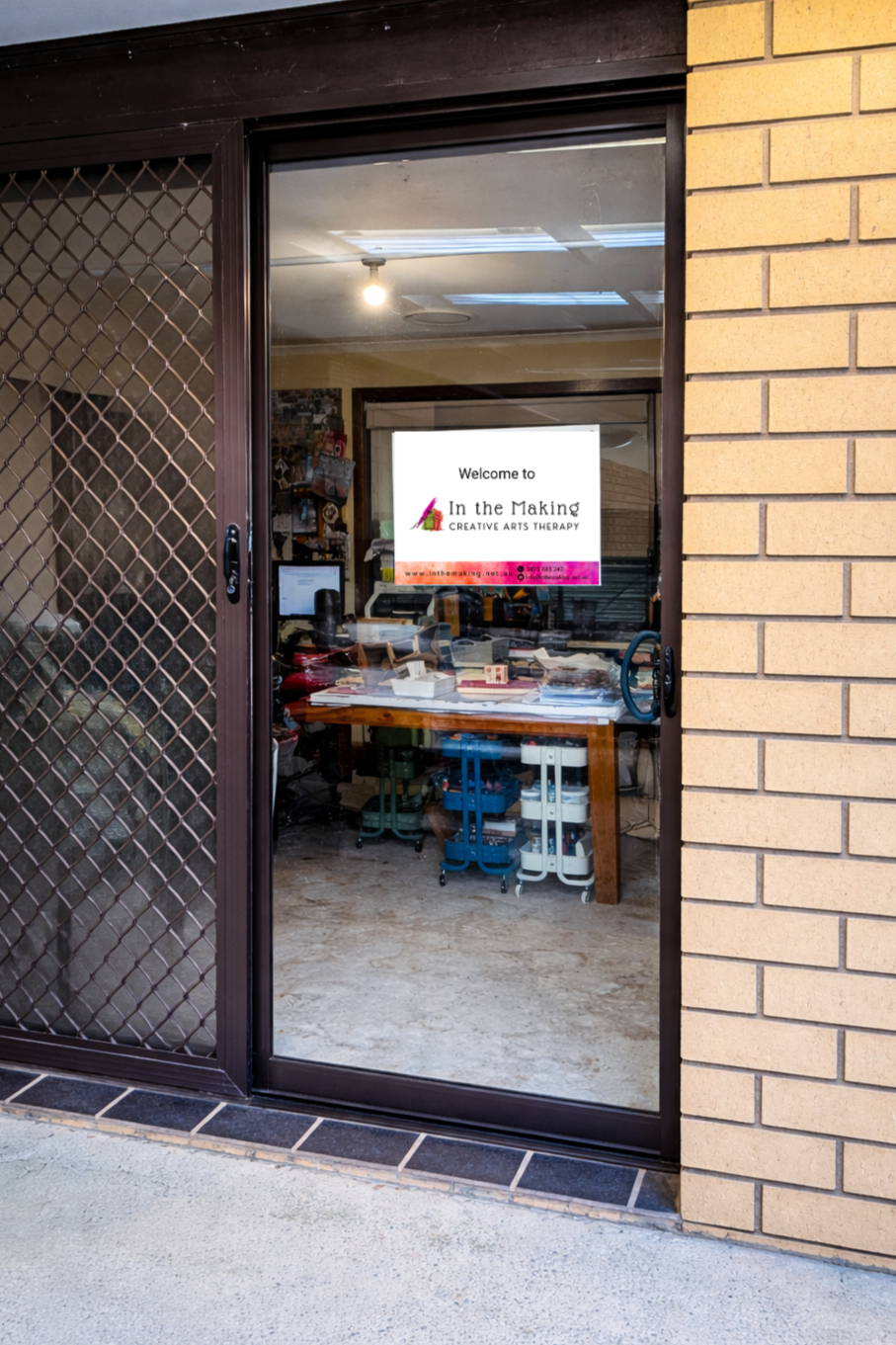Glass entry door to the In the Making studio with a welcome sign displayed on the inside.