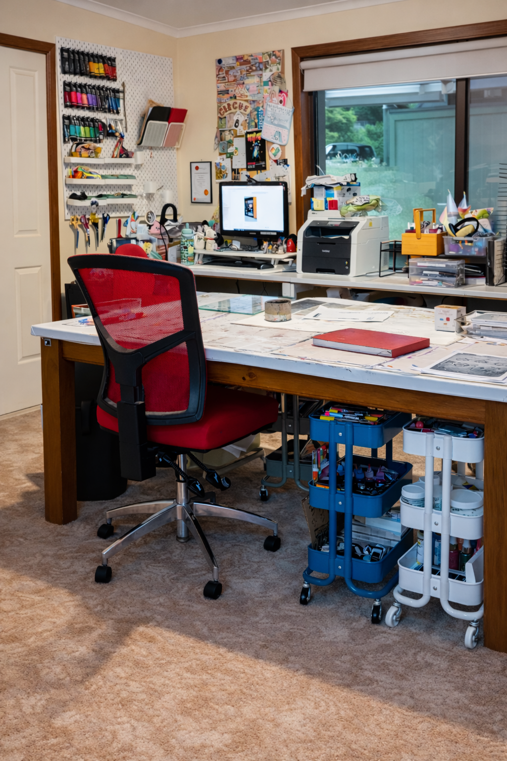 Interior view of the creative arts therapy studio showing a large work table, chair, and organised art materials.