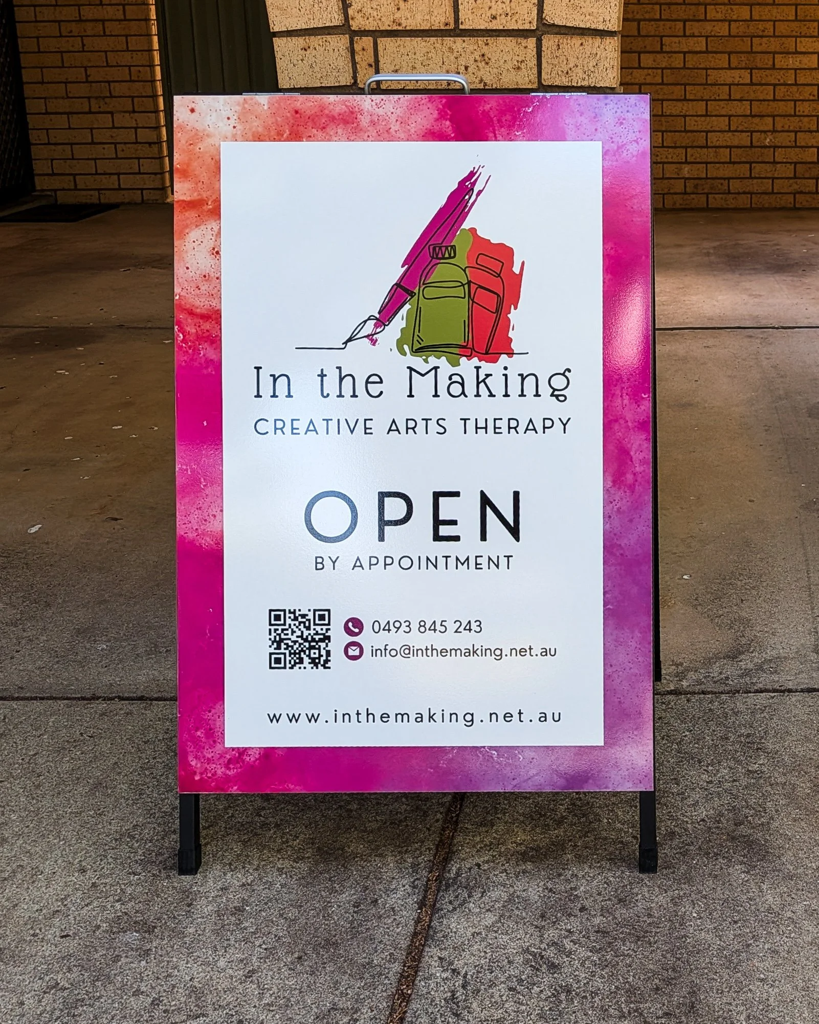 A-frame sign outside the In the Making studio reading “Open by appointment” with contact details.