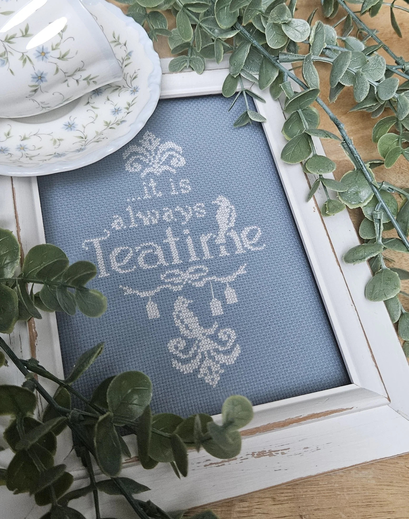 A decorative framed cross-stitch display.