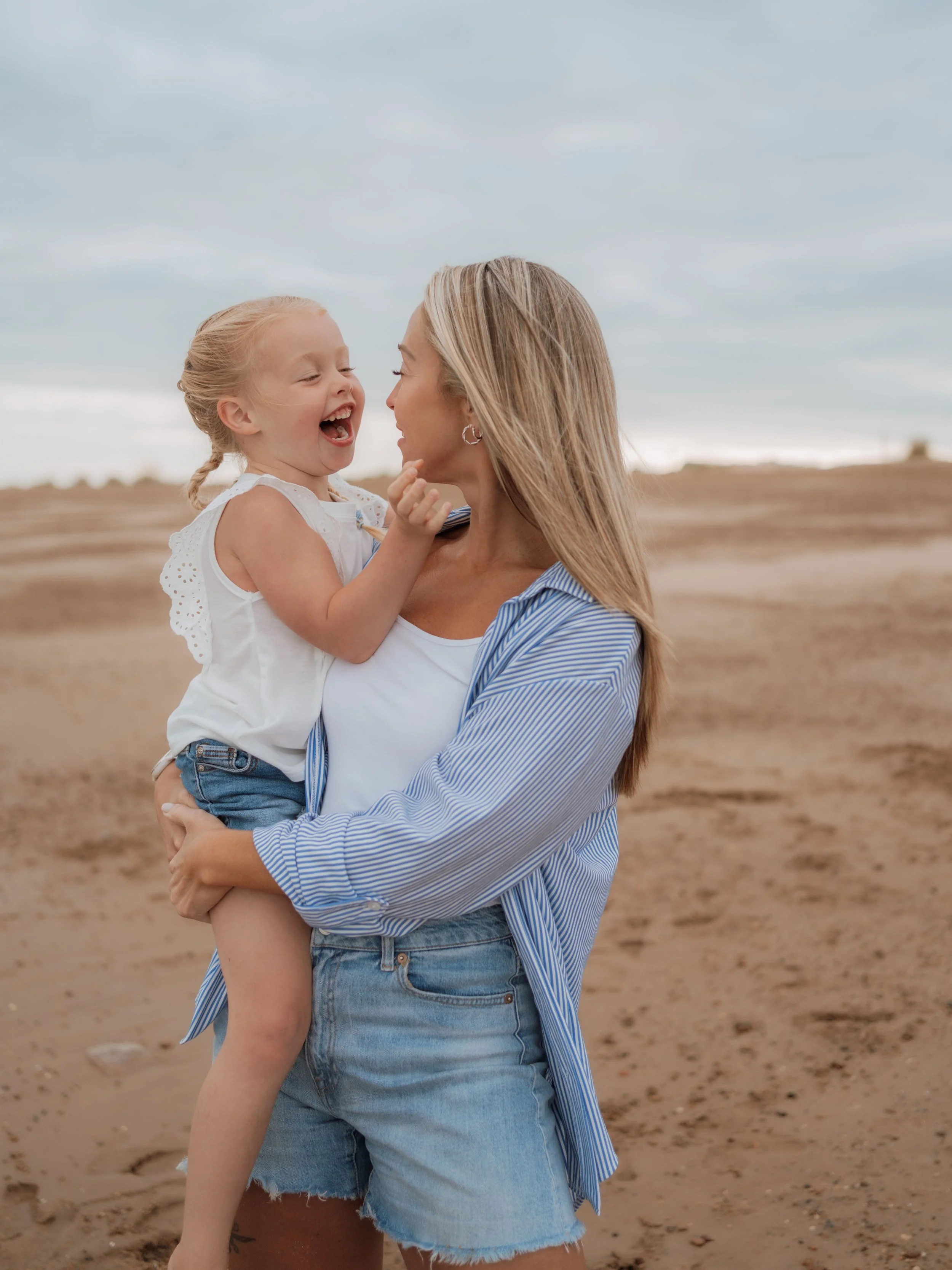 Natural family photography at Felixstowe Beach in Suffolk, capturing a mother and child sharing a joyful moment, photographed by Gemma Wythe Photography.