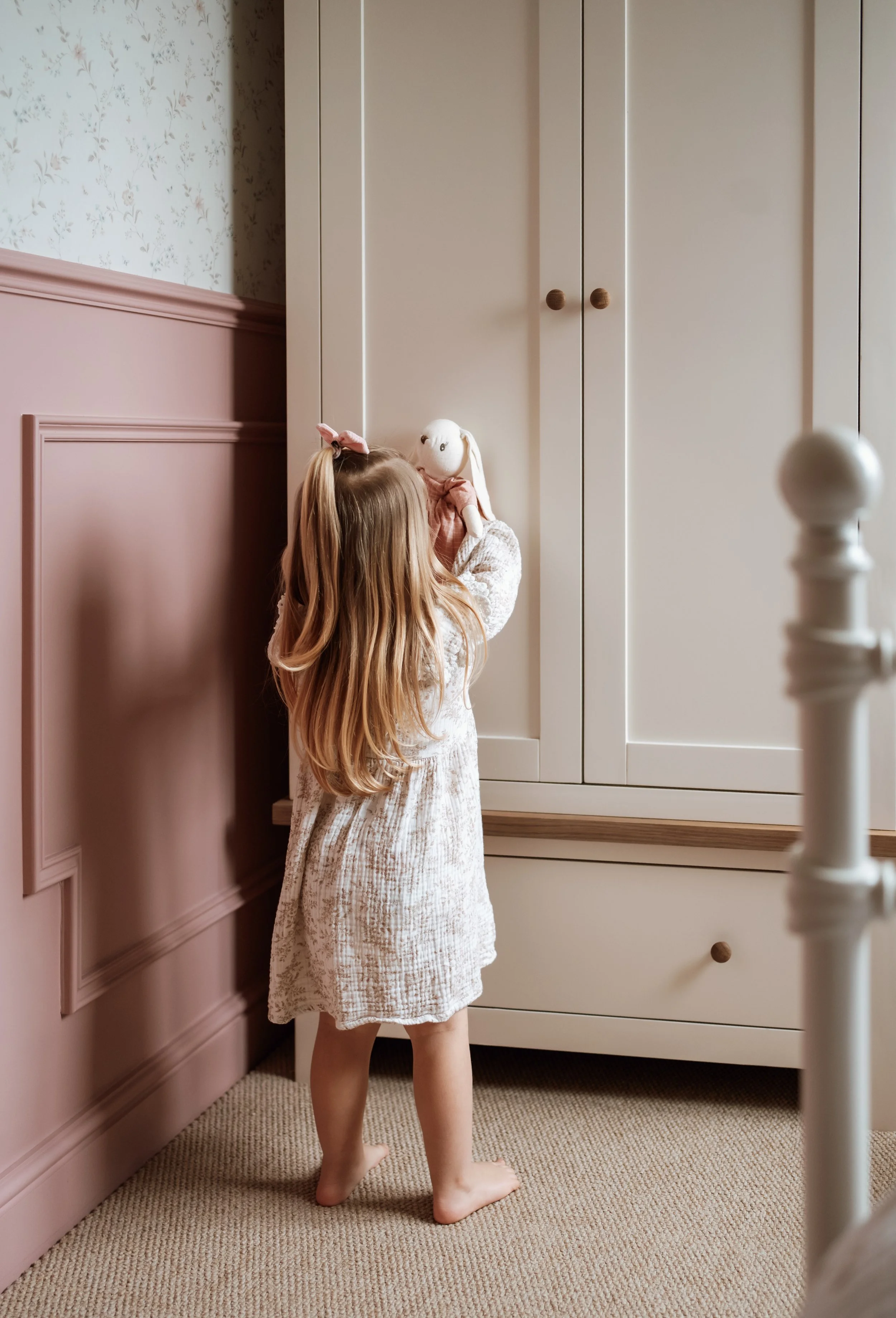 Child looking at a bunny toy in a vintage nursery