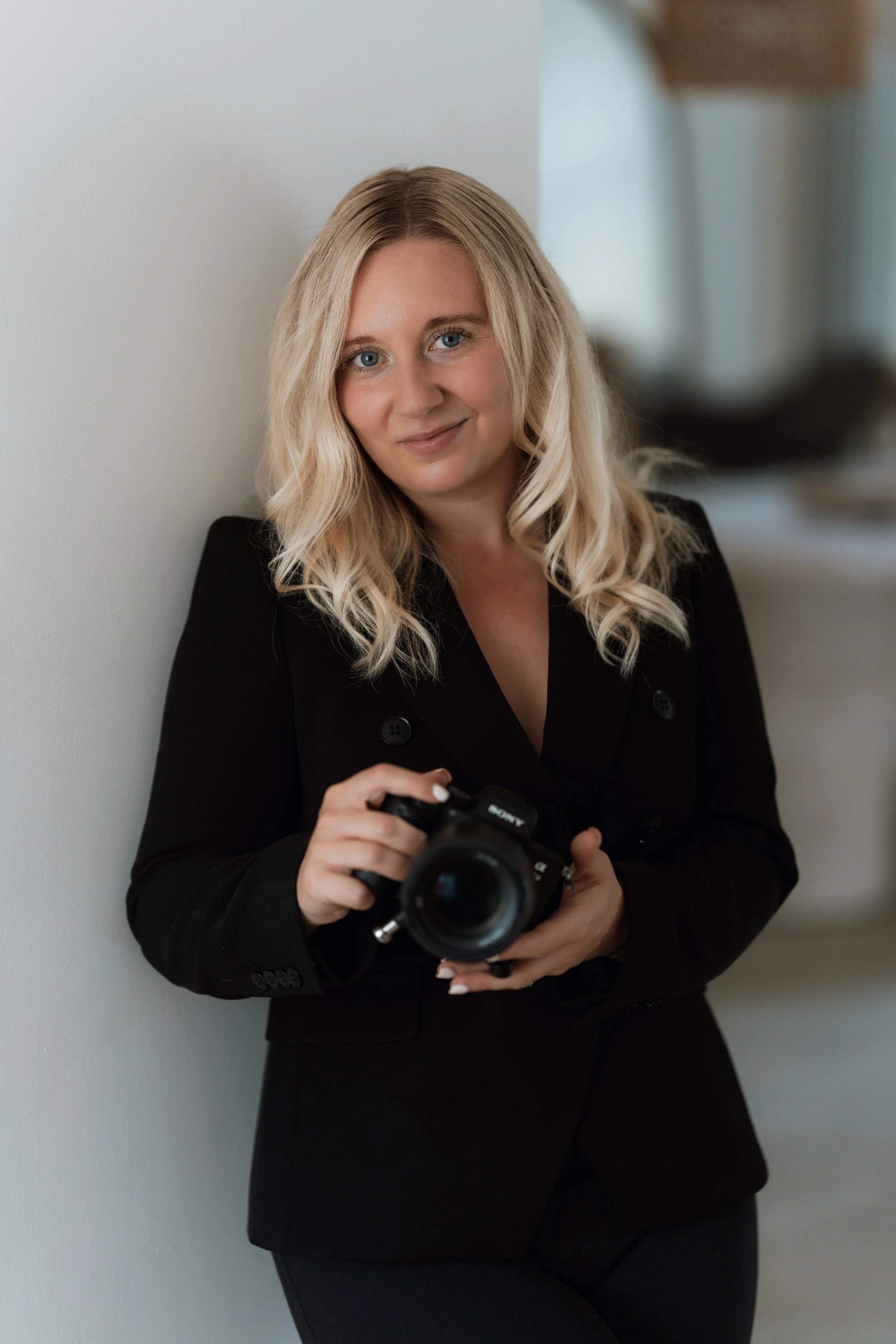 Portrait of Suffolk wedding photographer Gemma Wythe holding a camera.