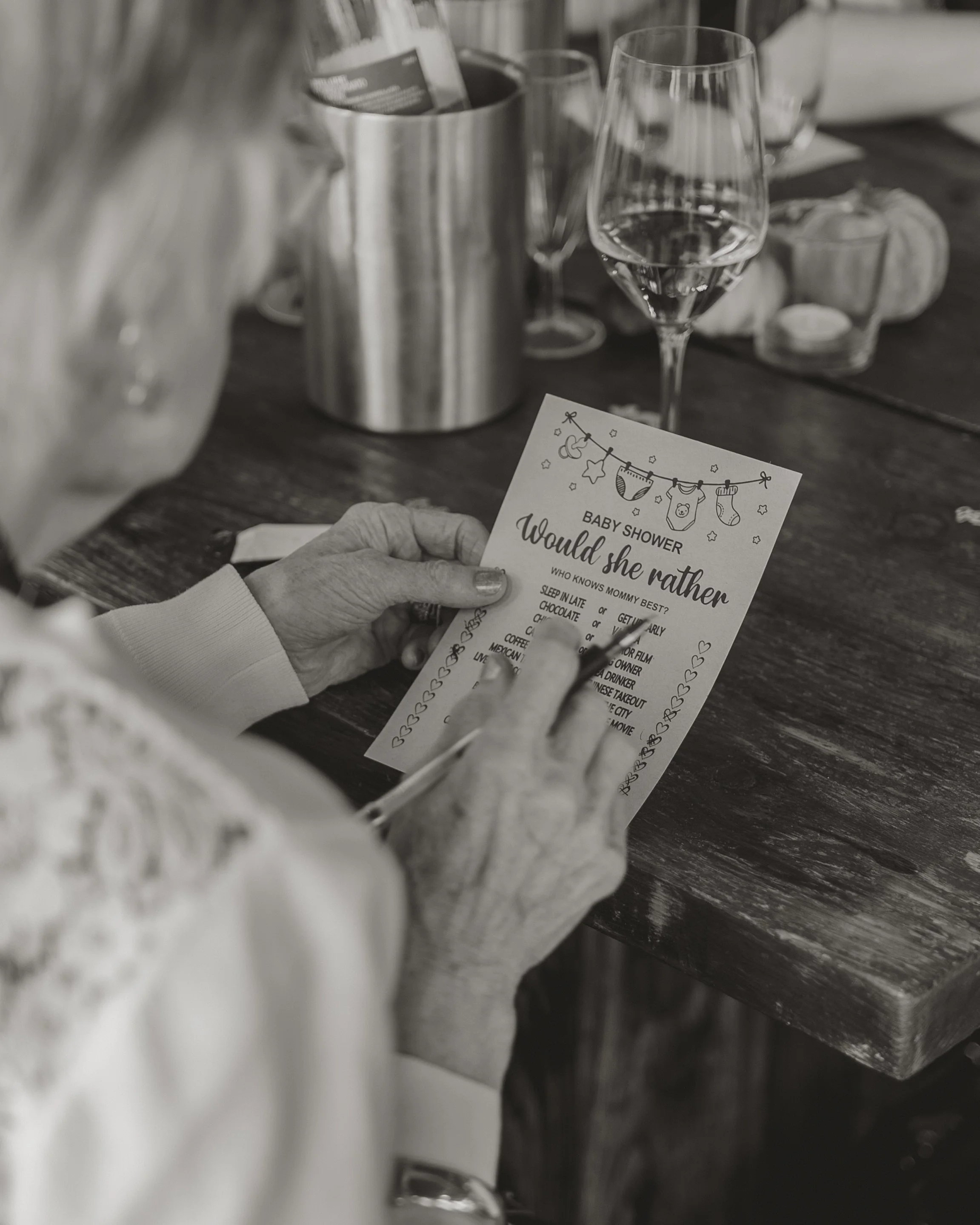 Candid baby shower event photography at The Boathouse in Woodbridge, Suffolk, capturing guests taking part in a baby shower game, photographed by Gemma Wythe Photography.