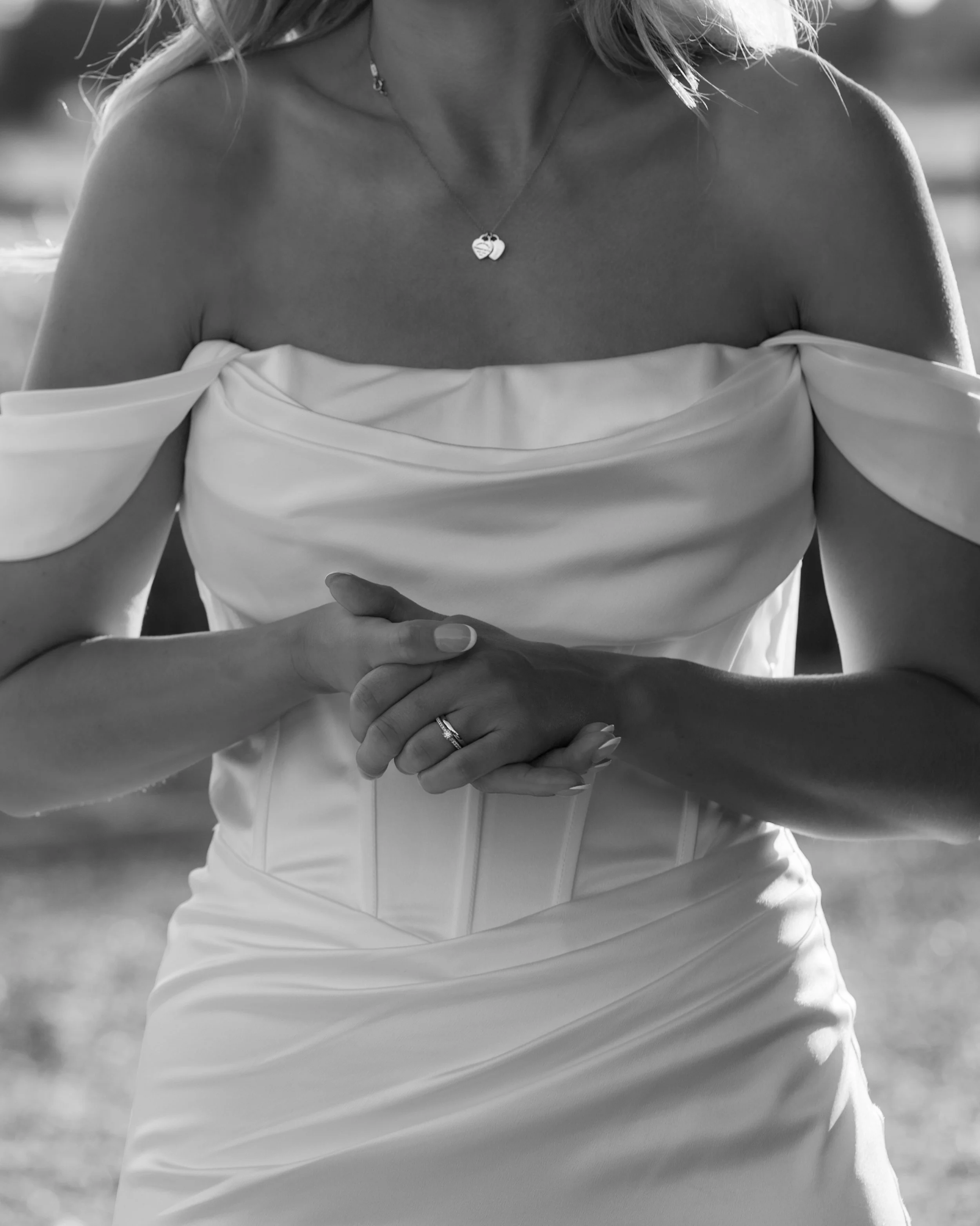 Black and white bridal detail portrait showing the bride's wedding dress and jewellery.