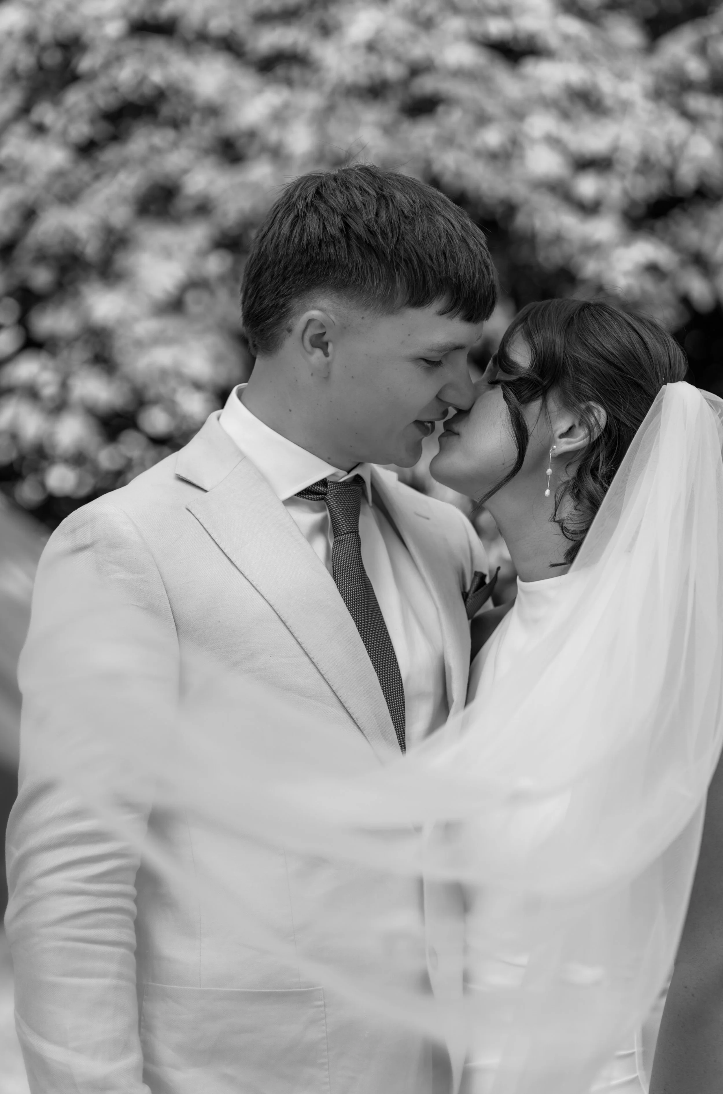Intimate black and white portrait of a bride and groom outdoors.