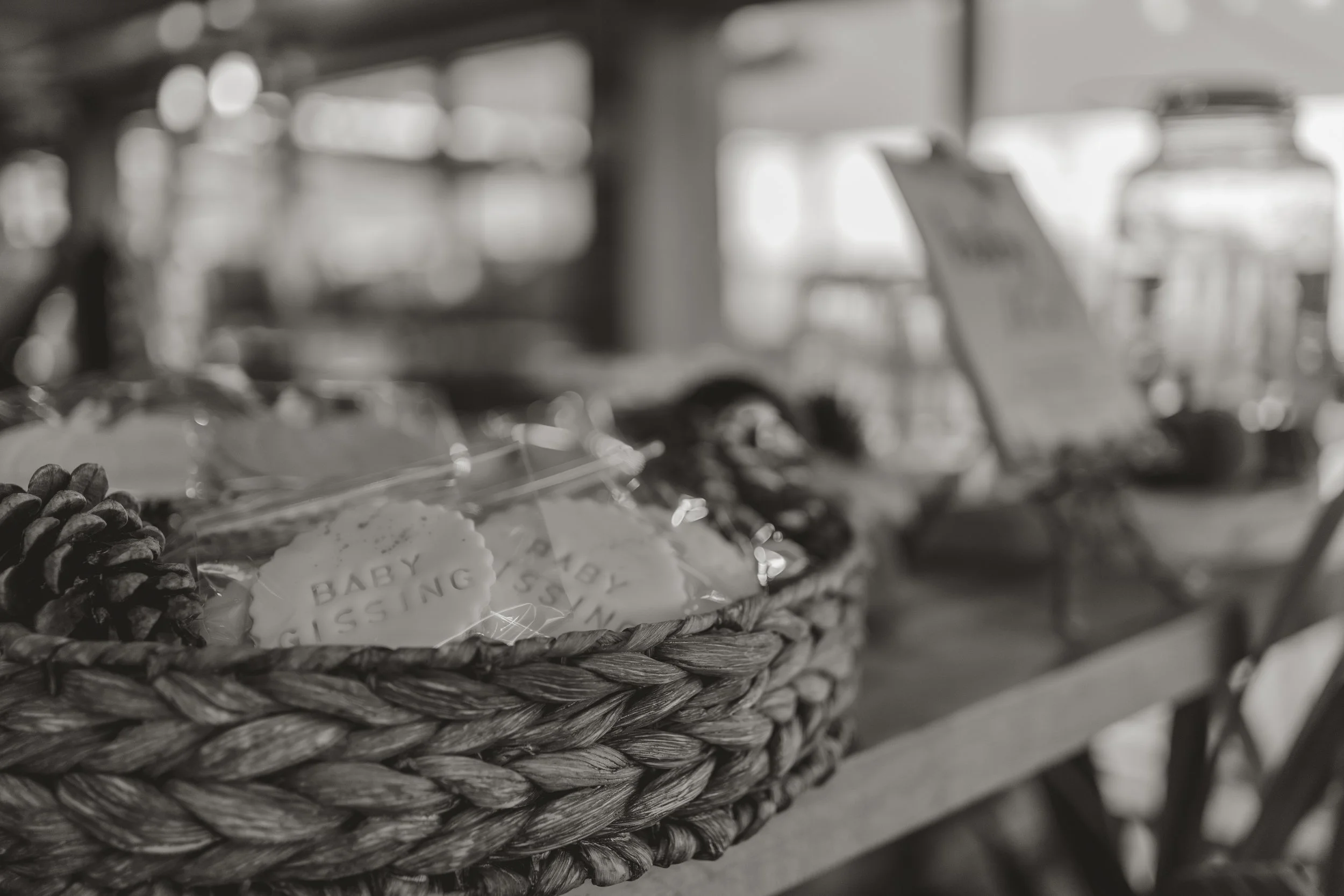 Basket with cookies and pinecones on a wooden surface at a store or café.