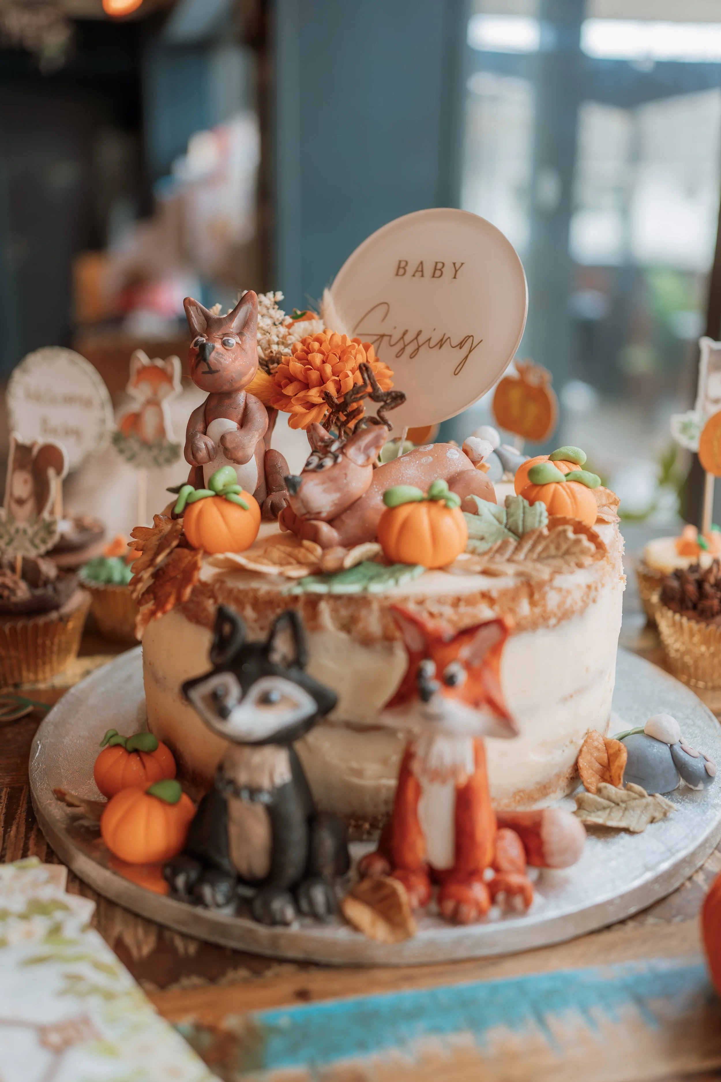 Candid baby shower event photography at The Boathouse in Woodbridge, Suffolk, capturing styled cake and seasonal décor details, photographed by Gemma Wythe Photography.