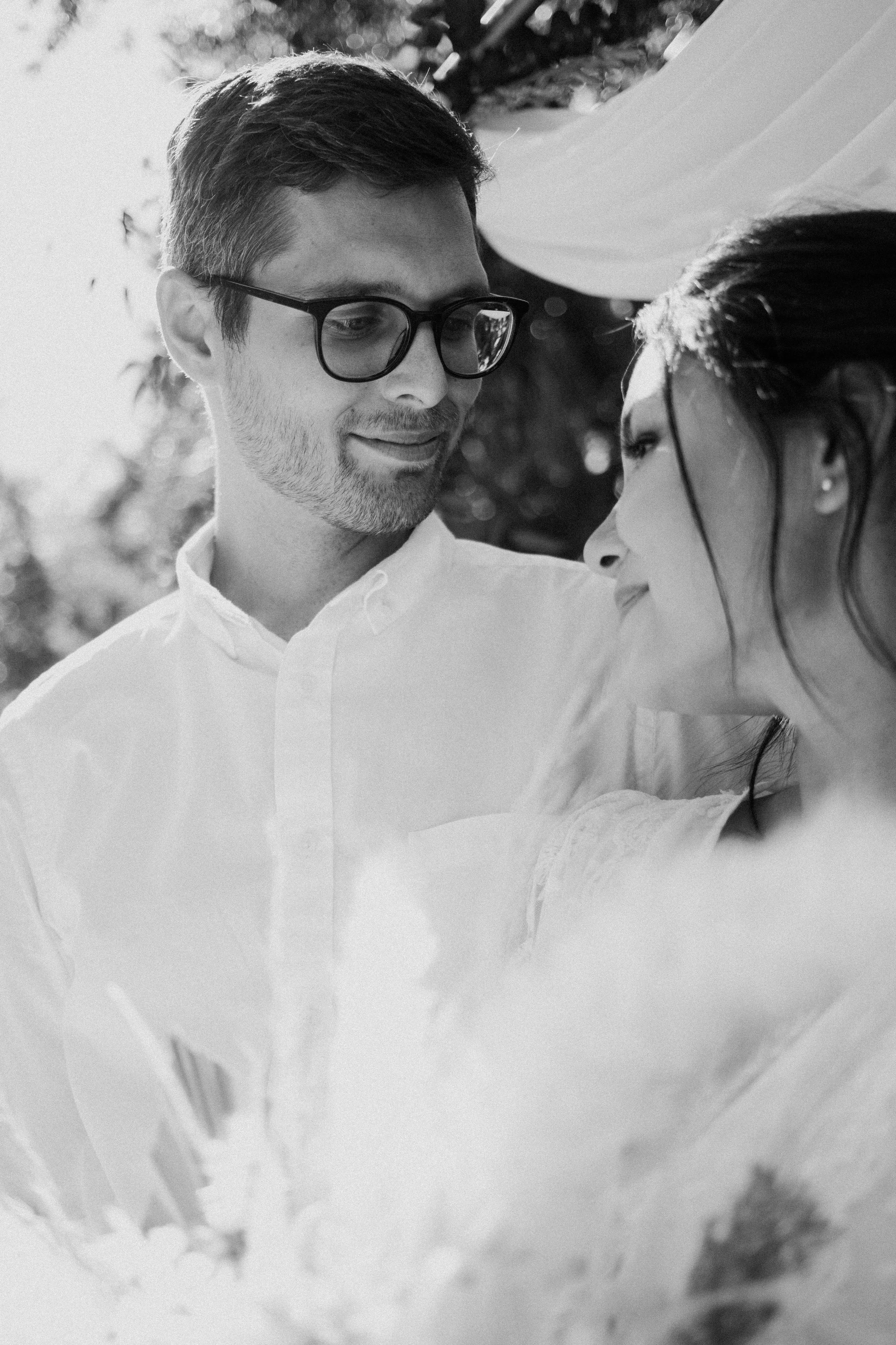 The groom smiles and looks down at his bride who is resting against him