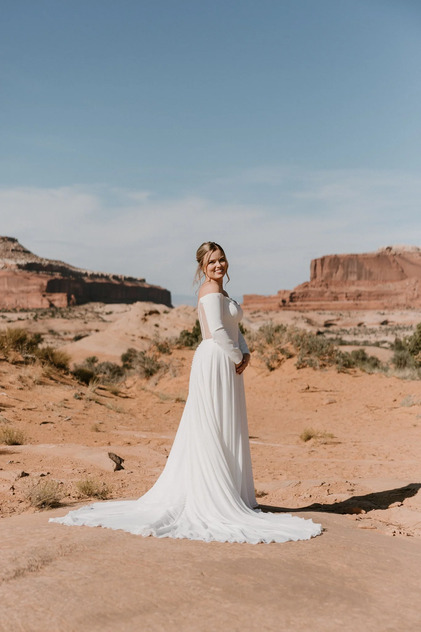 A bride shows off her wedding dress during her first look on BLM land outside of Dead Horse State Park