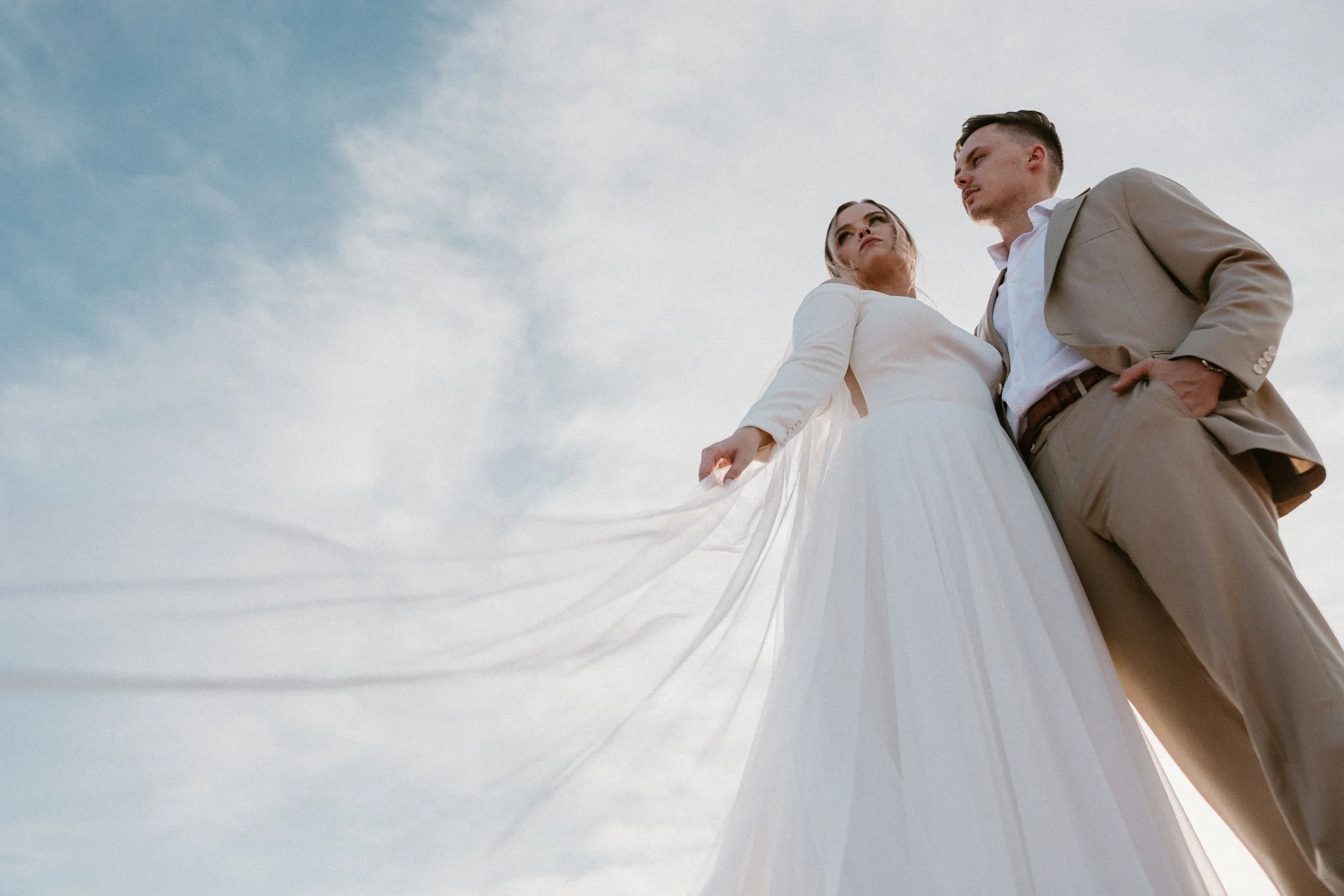 low perspective of a wedding couple amongst the clouds