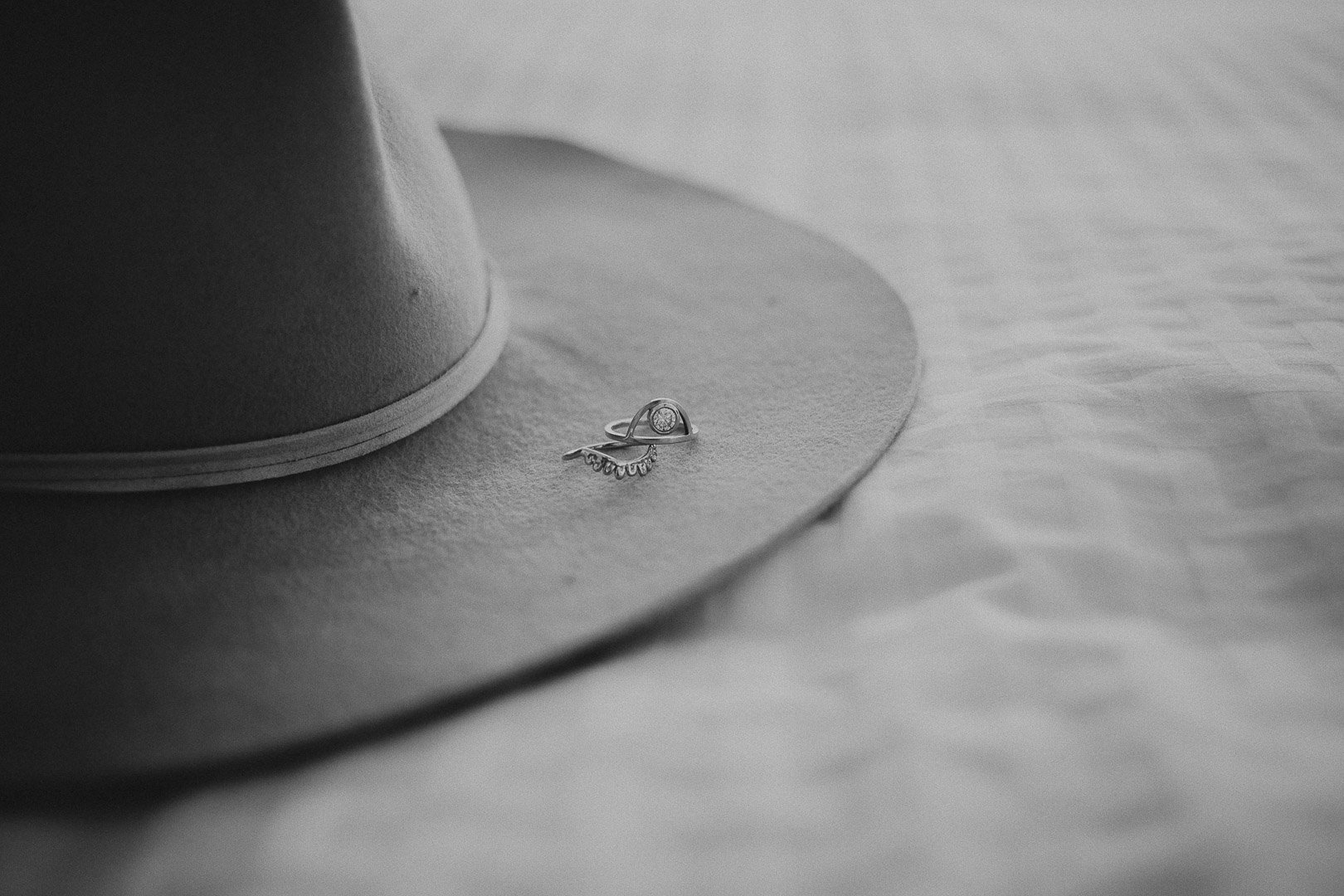 black and white photo of a brides hat with her rings