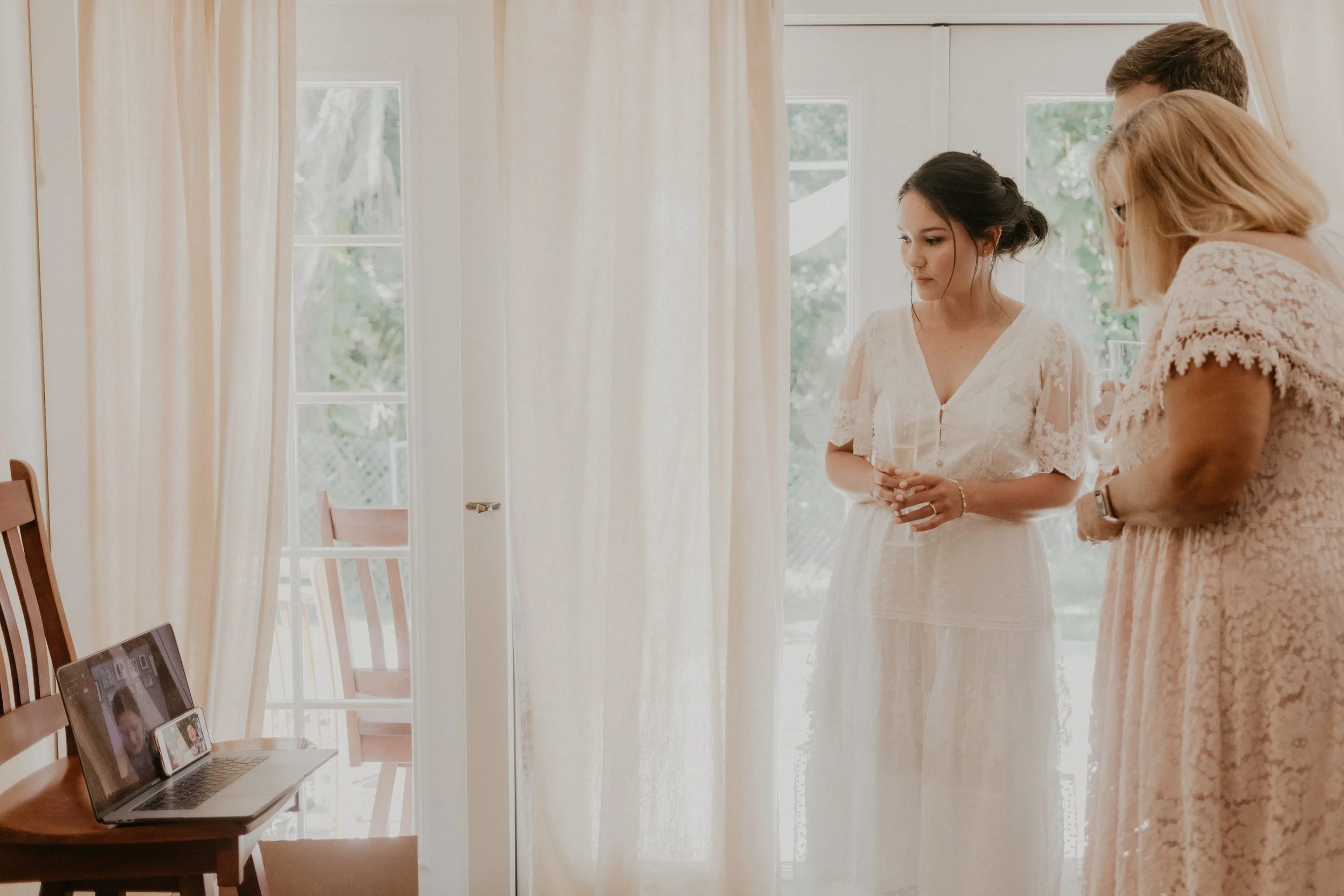 The bride, groom and mother-in-law speak to their Columbian relatives through the computer, and iPhone, propped up on a chair.