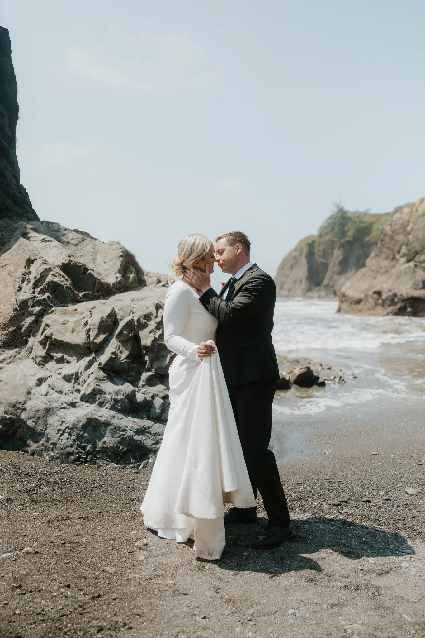 A wedding couple share a kiss on Ruby Beach in Olympic National Park