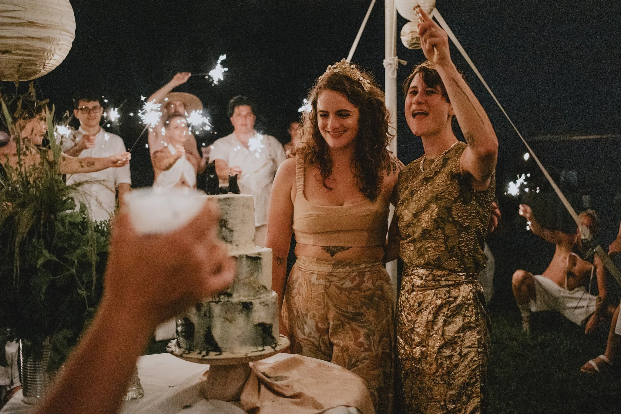 brides have a toast while preparing to cut their cake