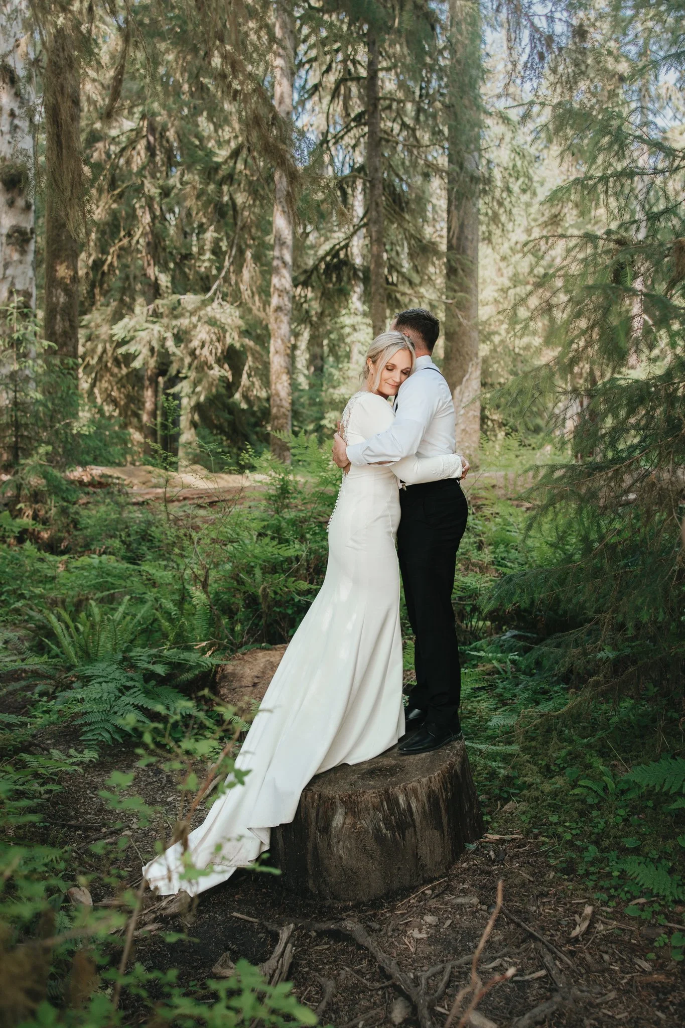 Couple embraces on a downed tree in Olympic National Park Hall of Mosses