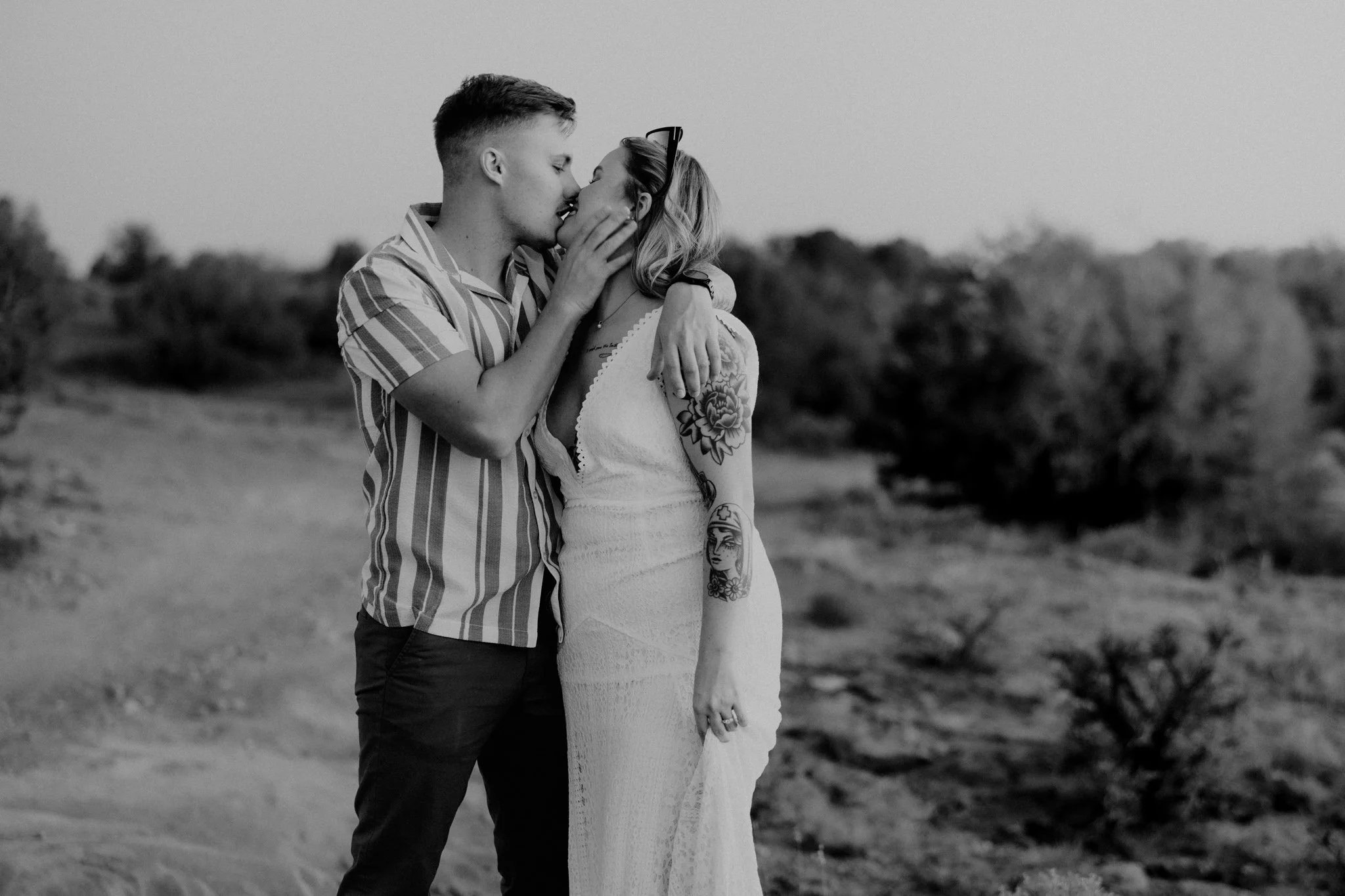 Black and white photo of a couple embracing during their proposal in Moab
