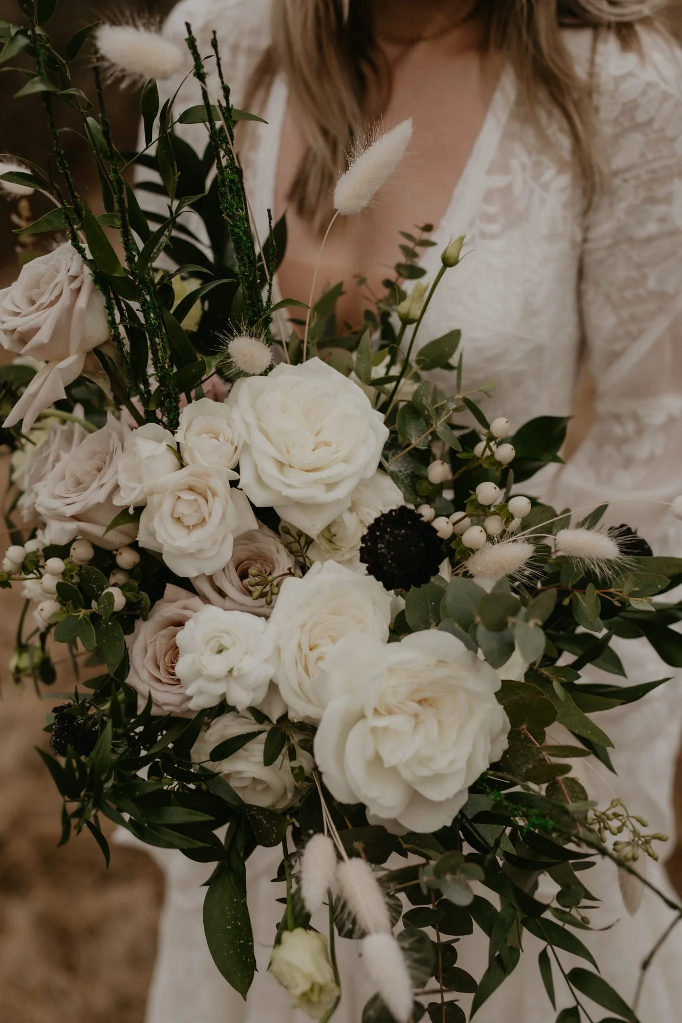 Close up of bridal bouquet showing white and dusty pink roses