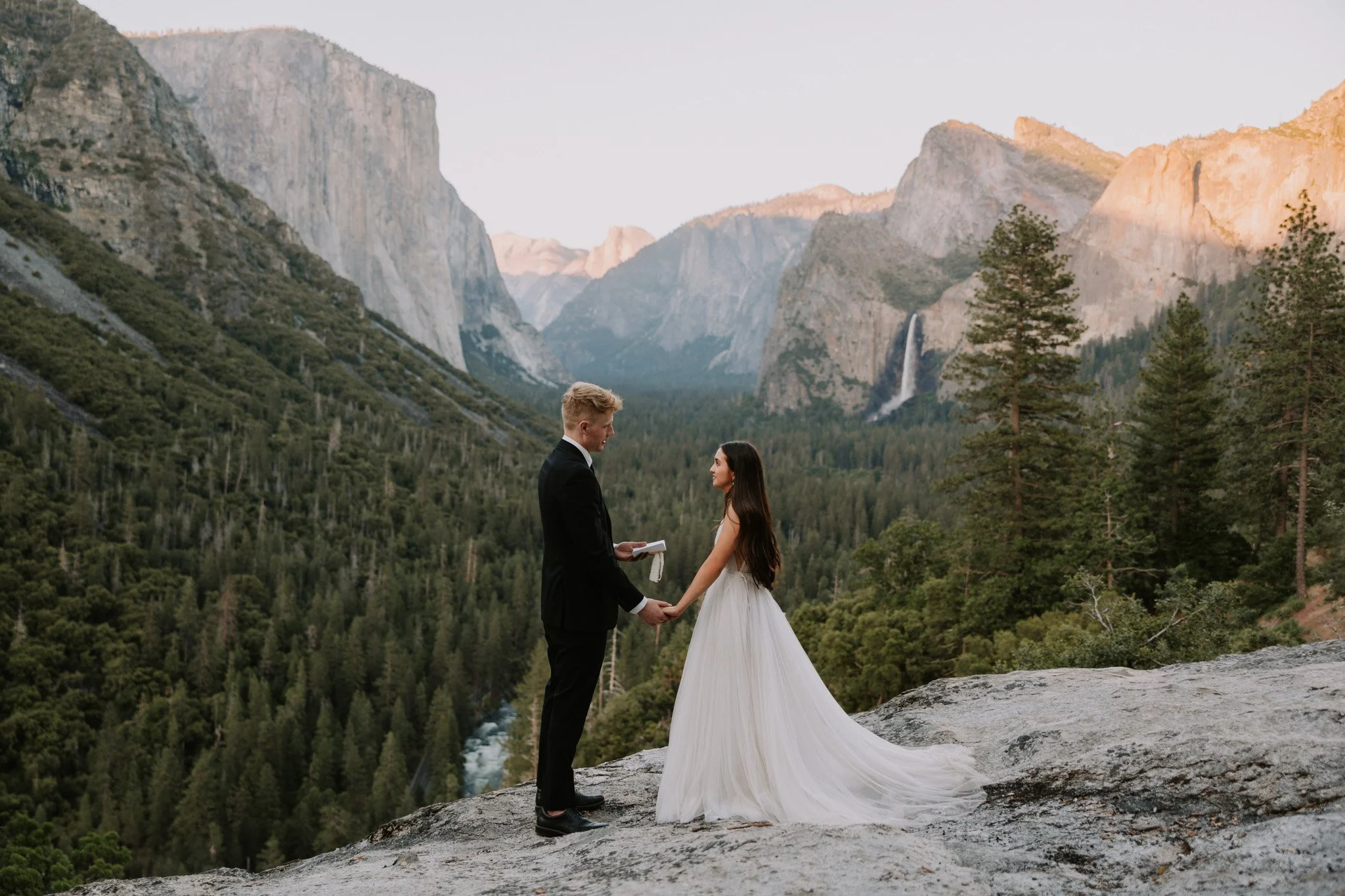 Couple shares wedding vows during their elopement in Yosemite with Valley View behind them at sunset