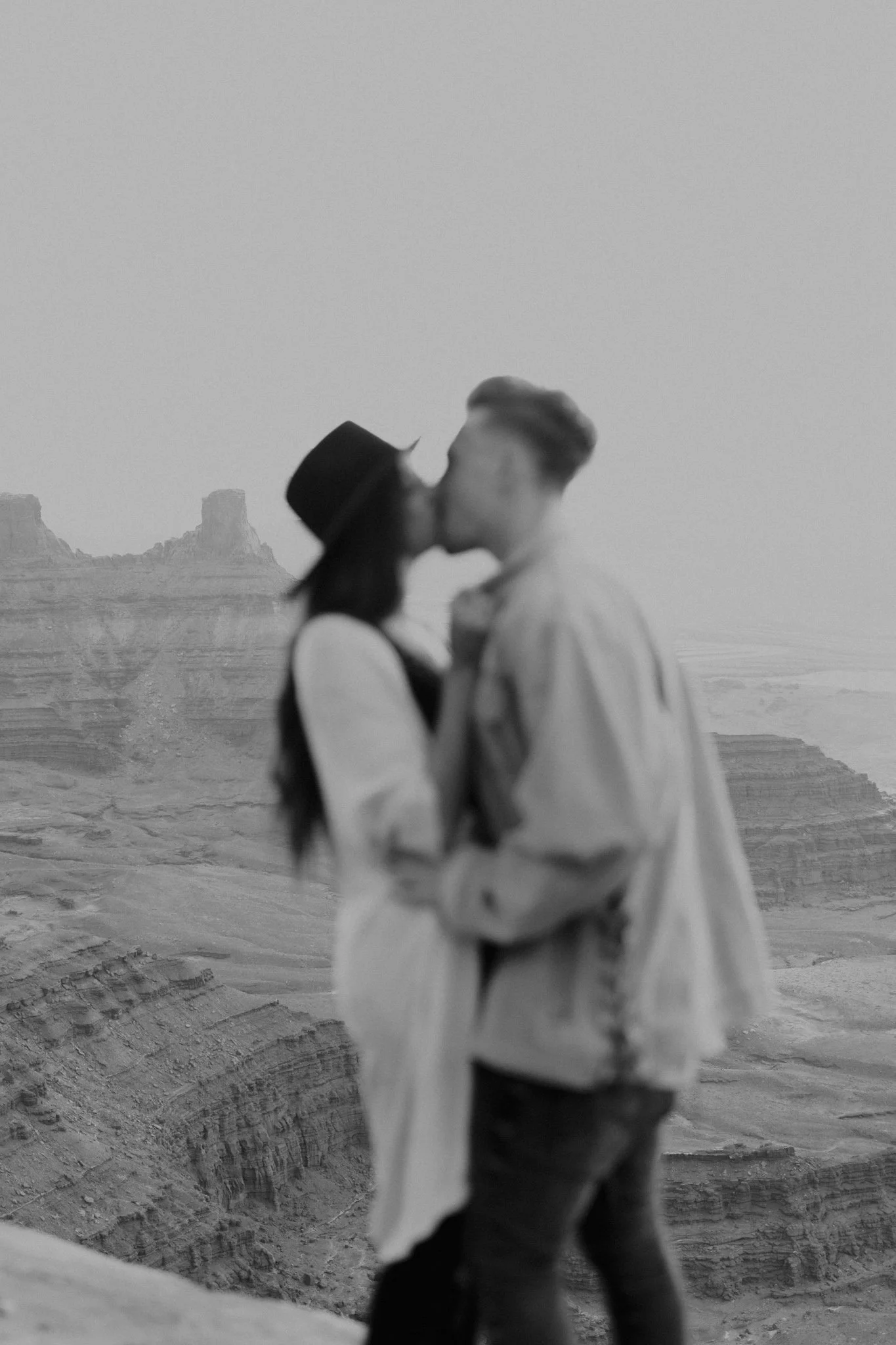 Black and white photo of a couple kissing at Dead Horse Point during their engagement