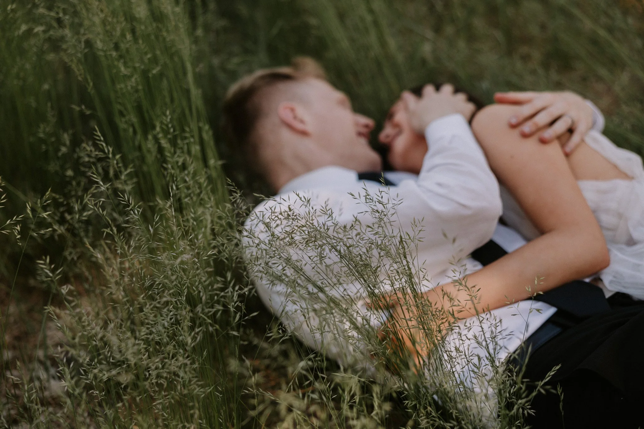 A couple shares a kiss in the tall grass in the Yosemite valley after their ceremony
