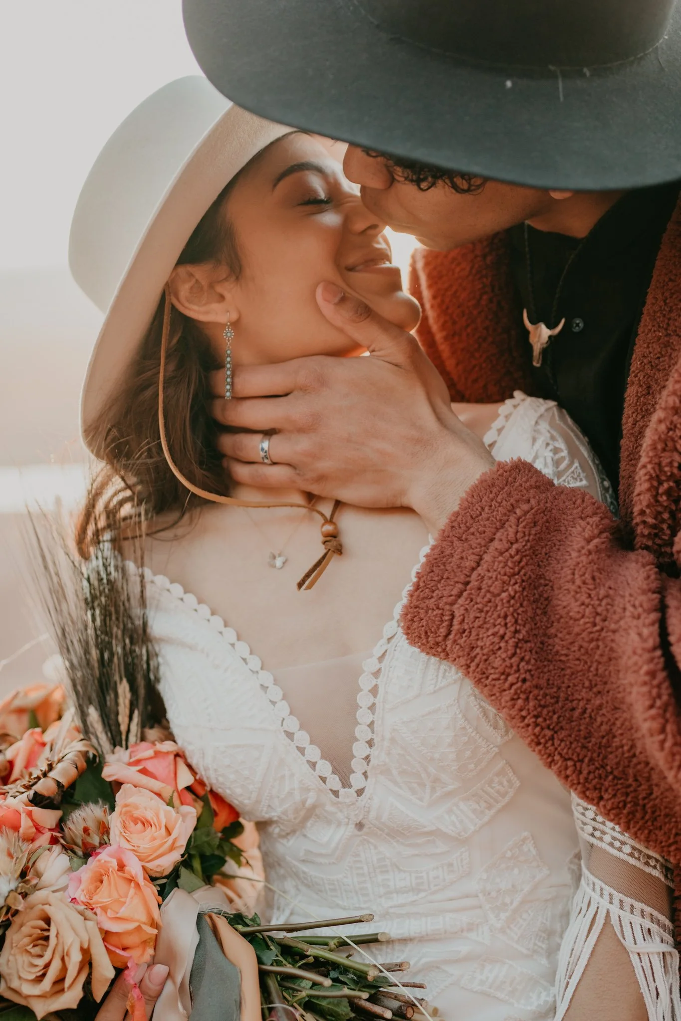 Boho couple shares a steamy kiss during their sunrise elopement at Dead Horse Point State Park