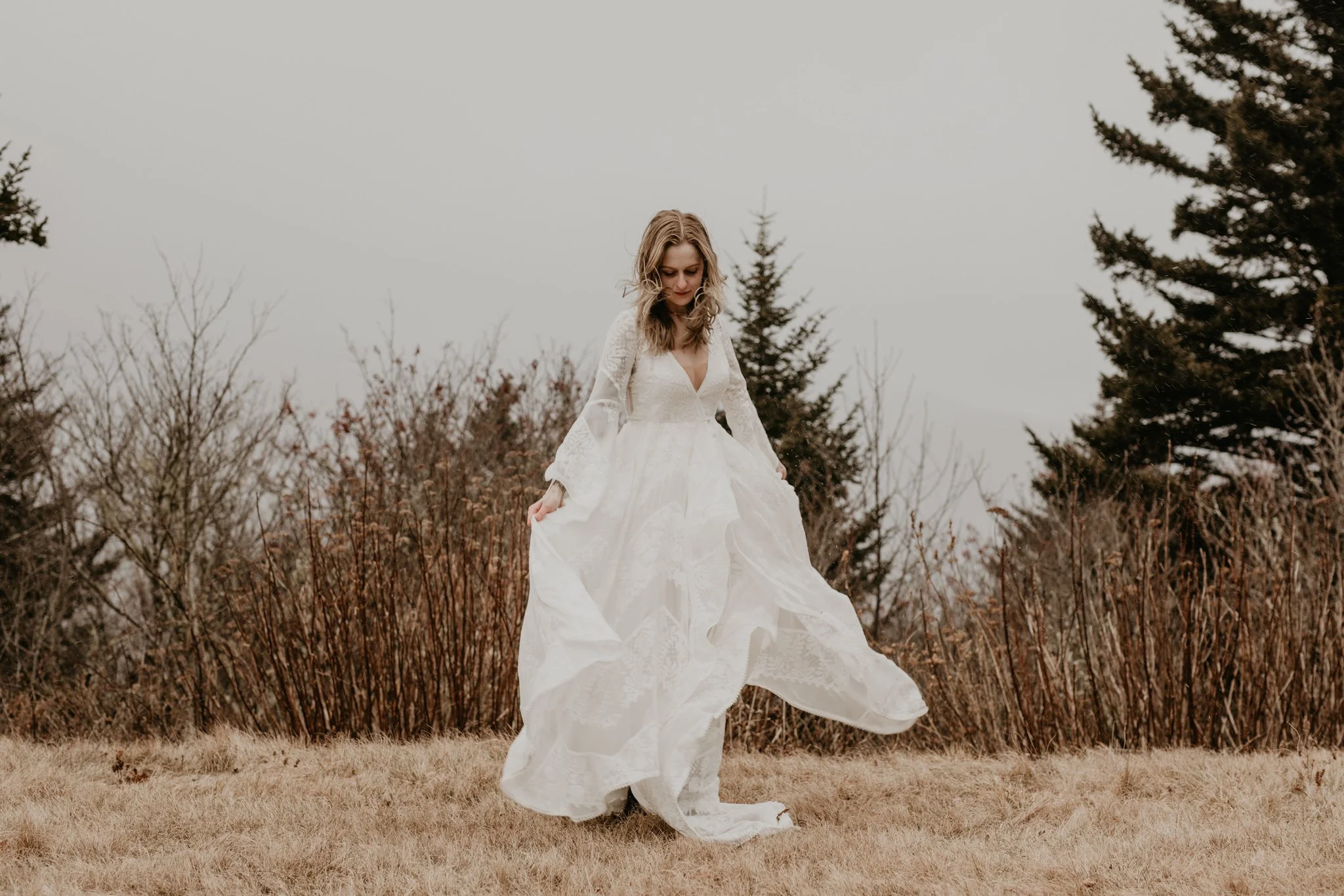 Bride moves in her dress during a white out on her elopement day in Pisgah National Forest