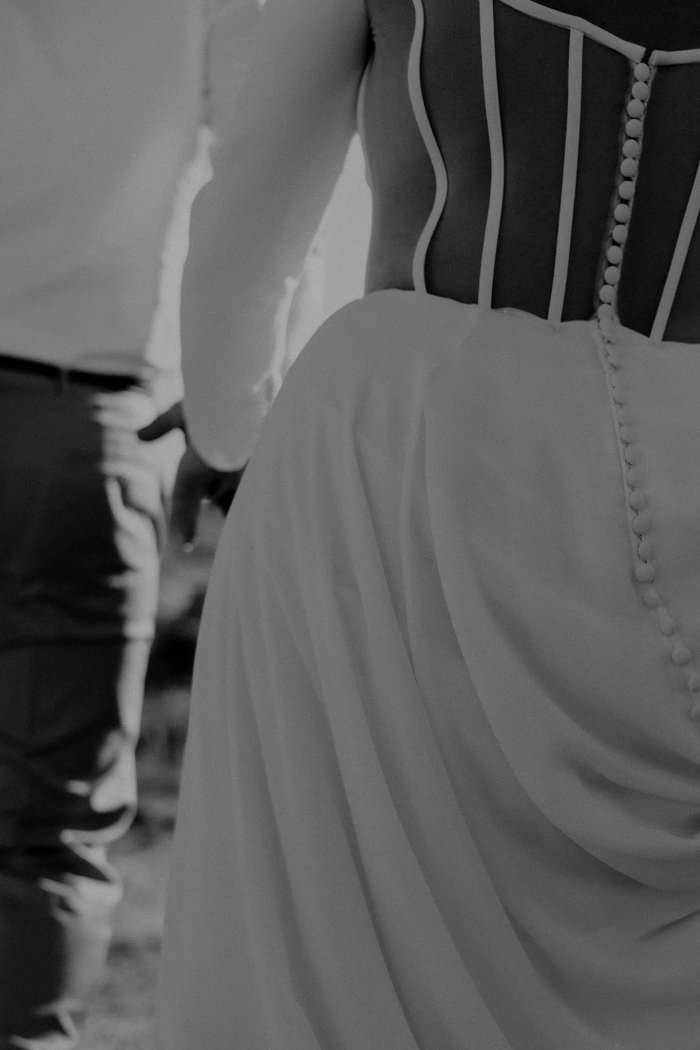 black and white image of a wedding couple walking, hand in hand
