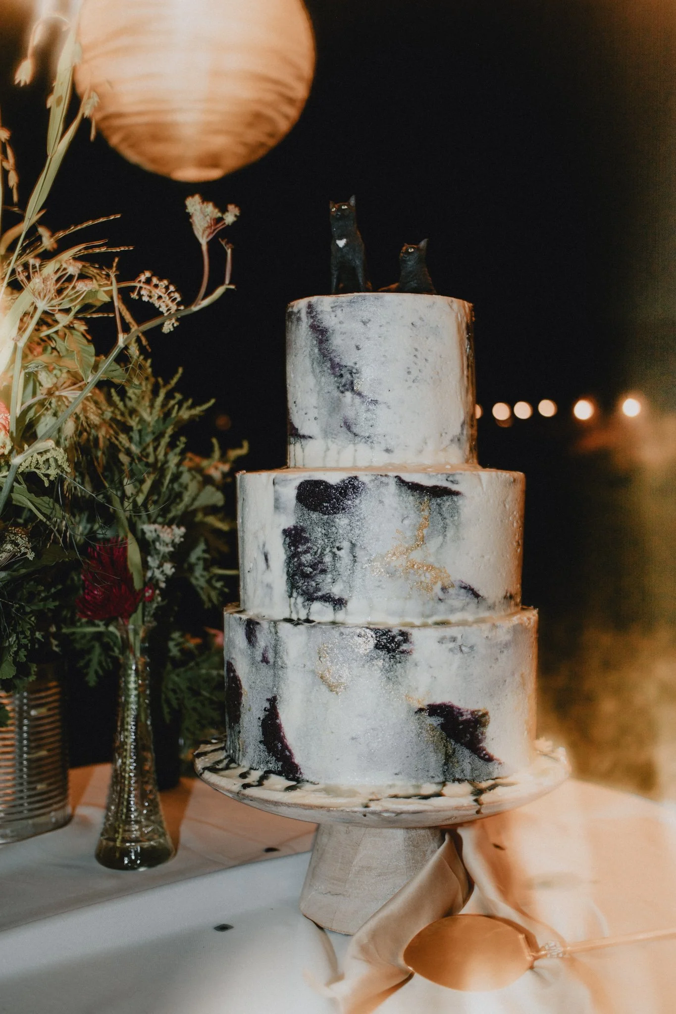 Their custom black and white marbled cake with two black cat figurines