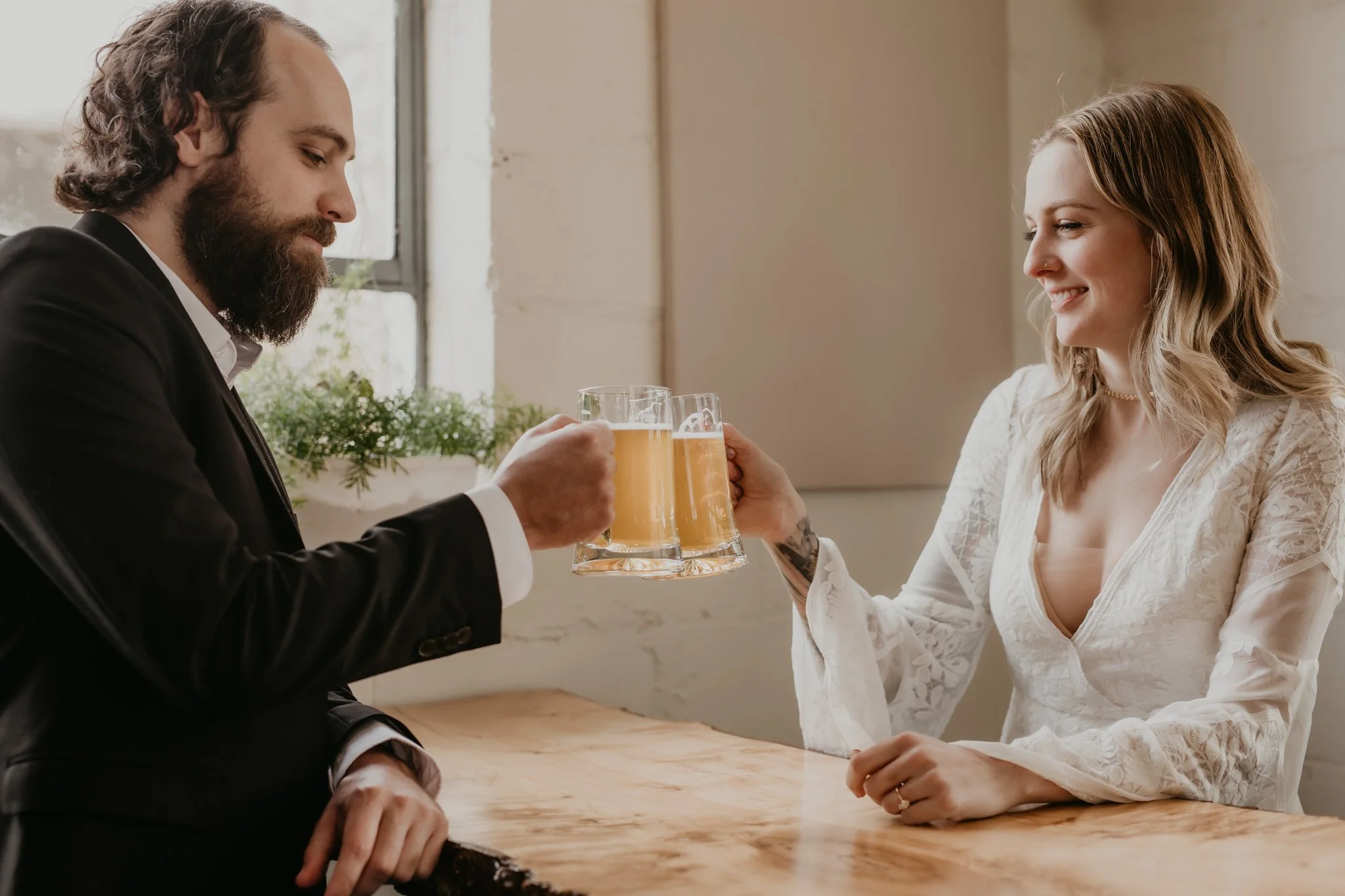 Bride and groom cheers their pints of beer before their wedding