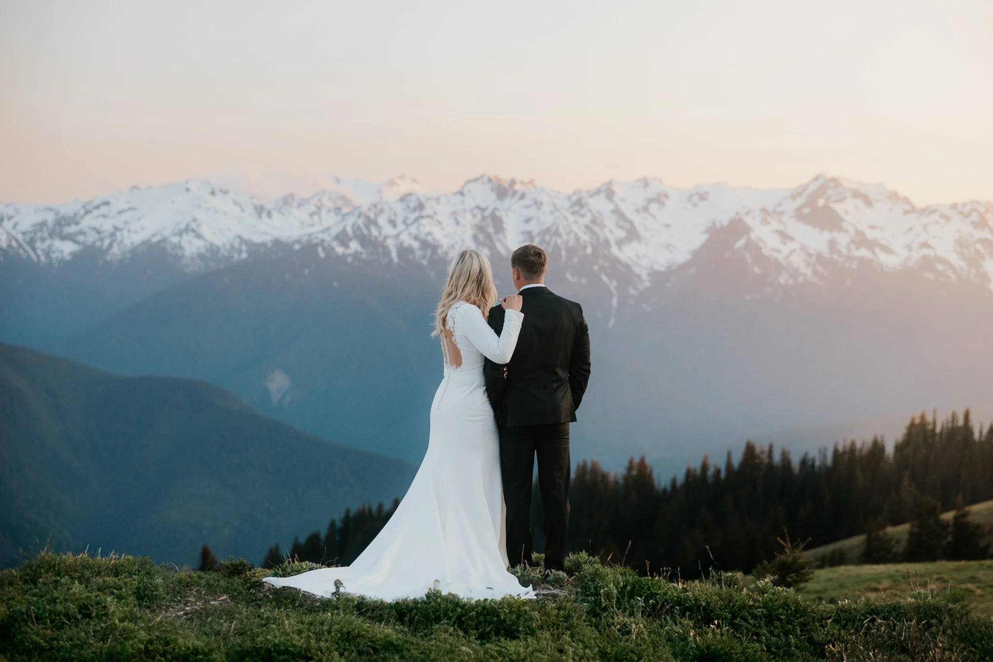 Wedding couple watches the sun set at Hurricane Ridge after their wedding day in Olympic National Park