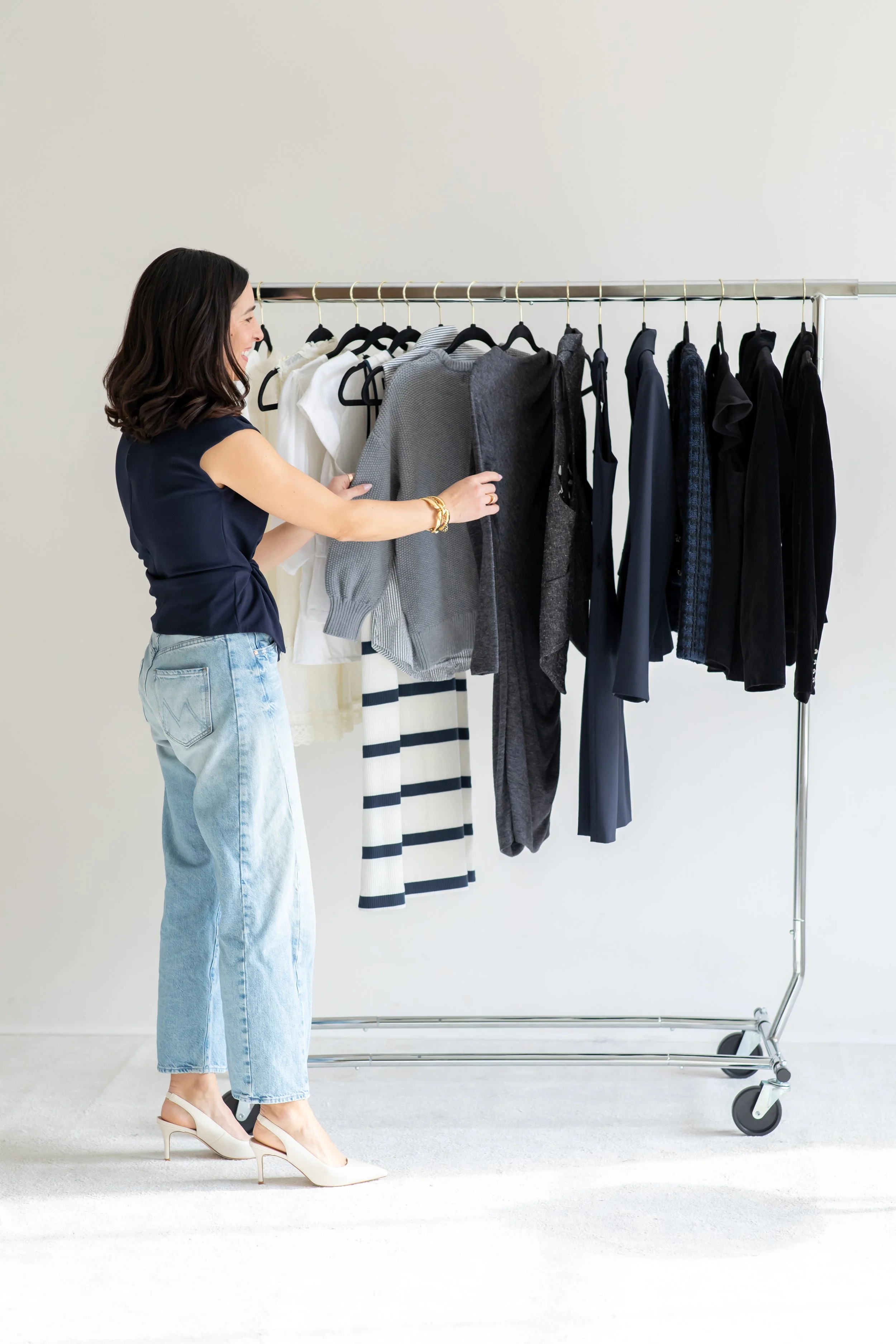 Kristin Wood reviewing clothing on a rack during a personal styling session.