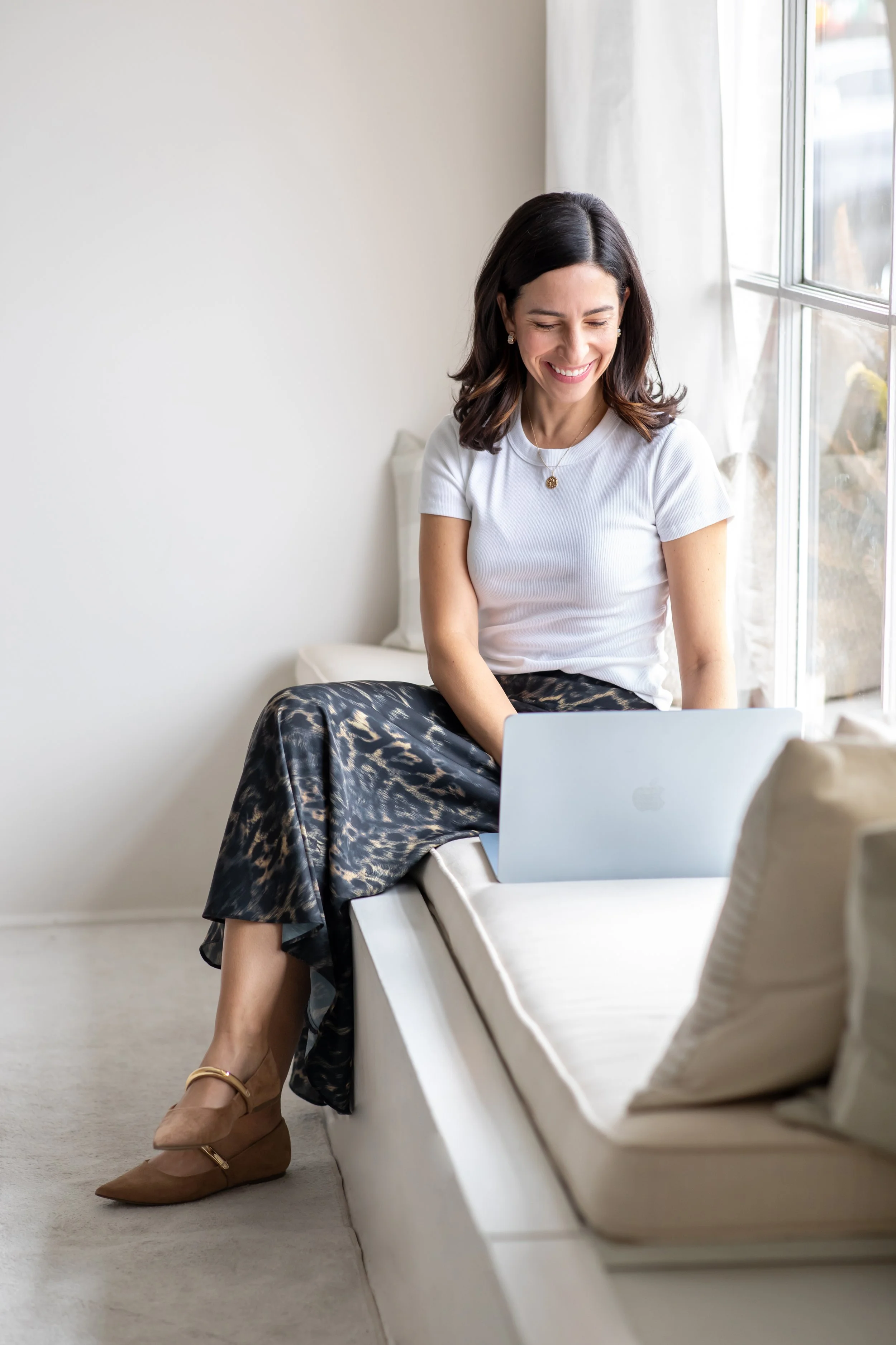 Kristin on a laptop, personal stylist and color analysis consultant.