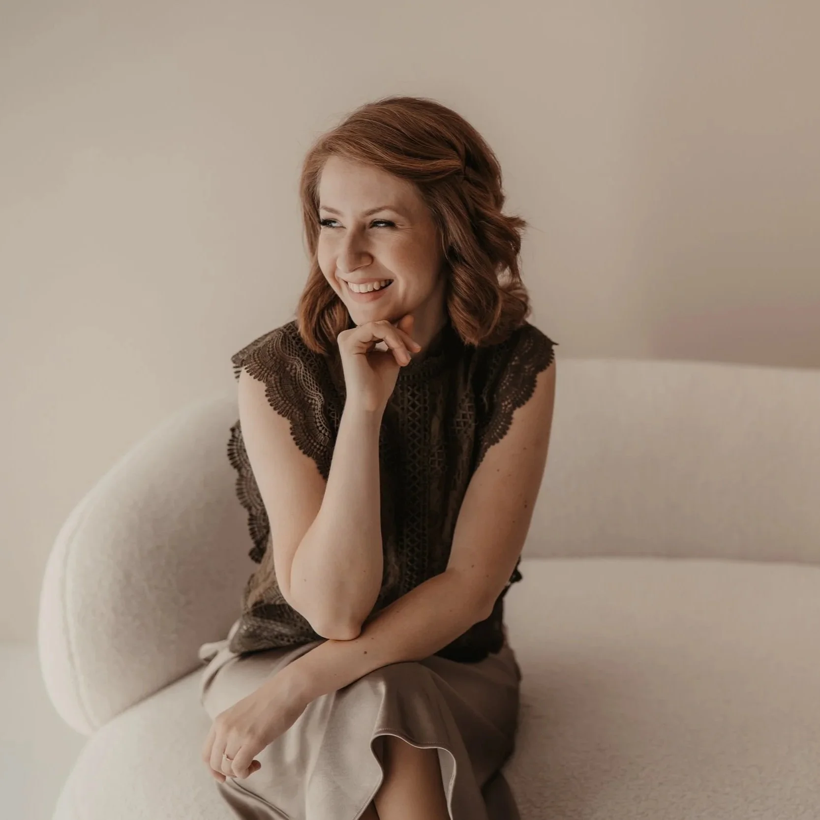 Innenarchitektin & Mentorin Eva Hofmann auf einem Sofa sitzend