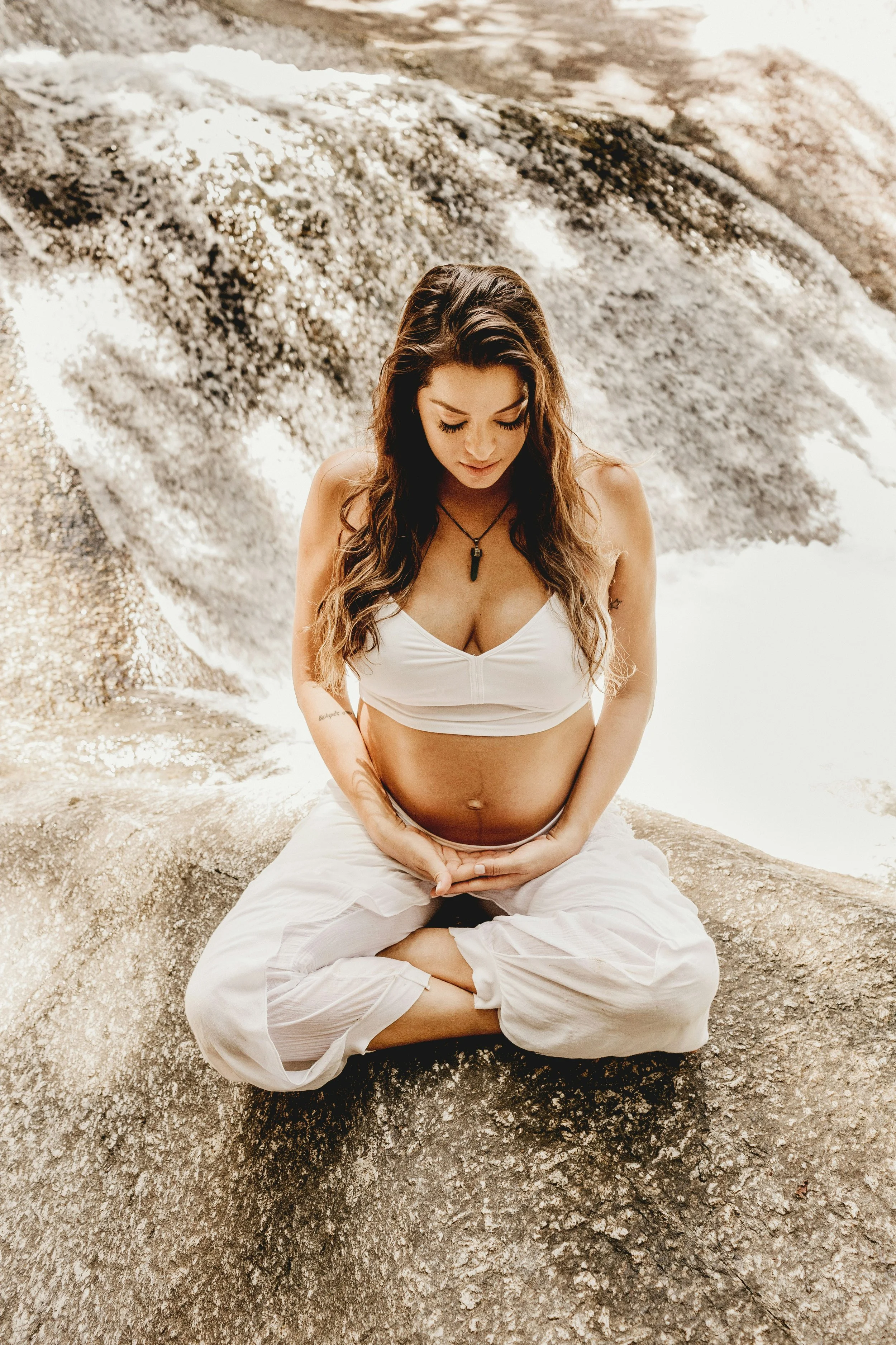 A pregnant woman sat crossed legged in meditation.