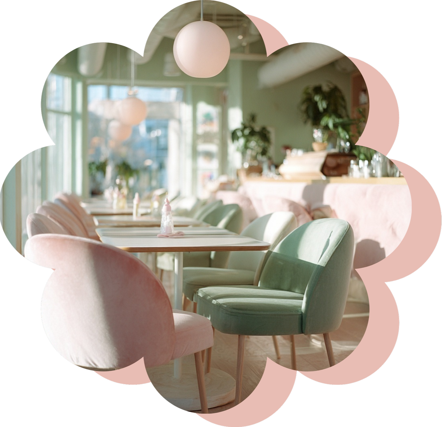 Interior of a brightly lit cafe with pastel-colored chairs and tables, hanging round pendant lights, and large windows with greenery outside.