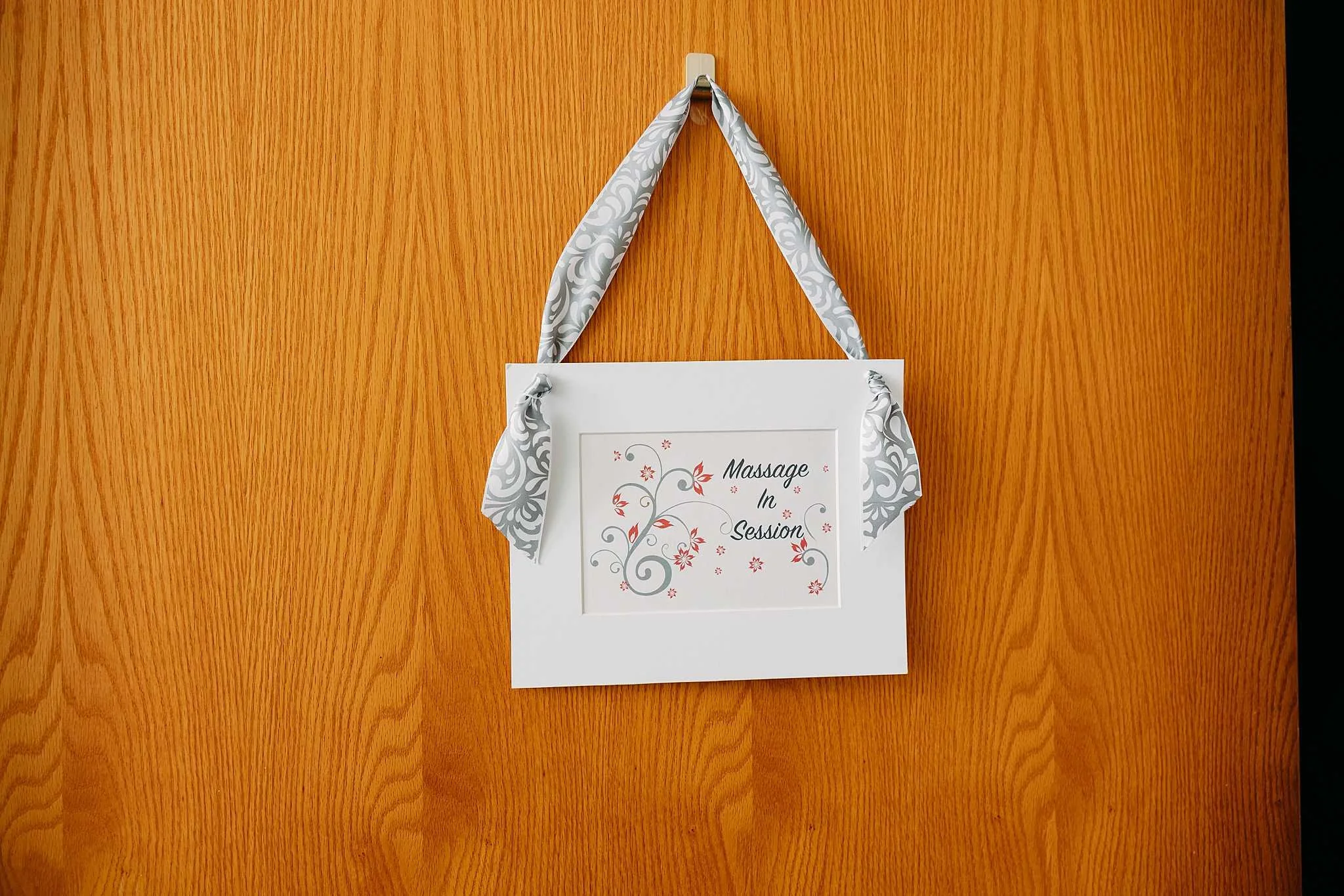 door hanging sign that says "massage in session"