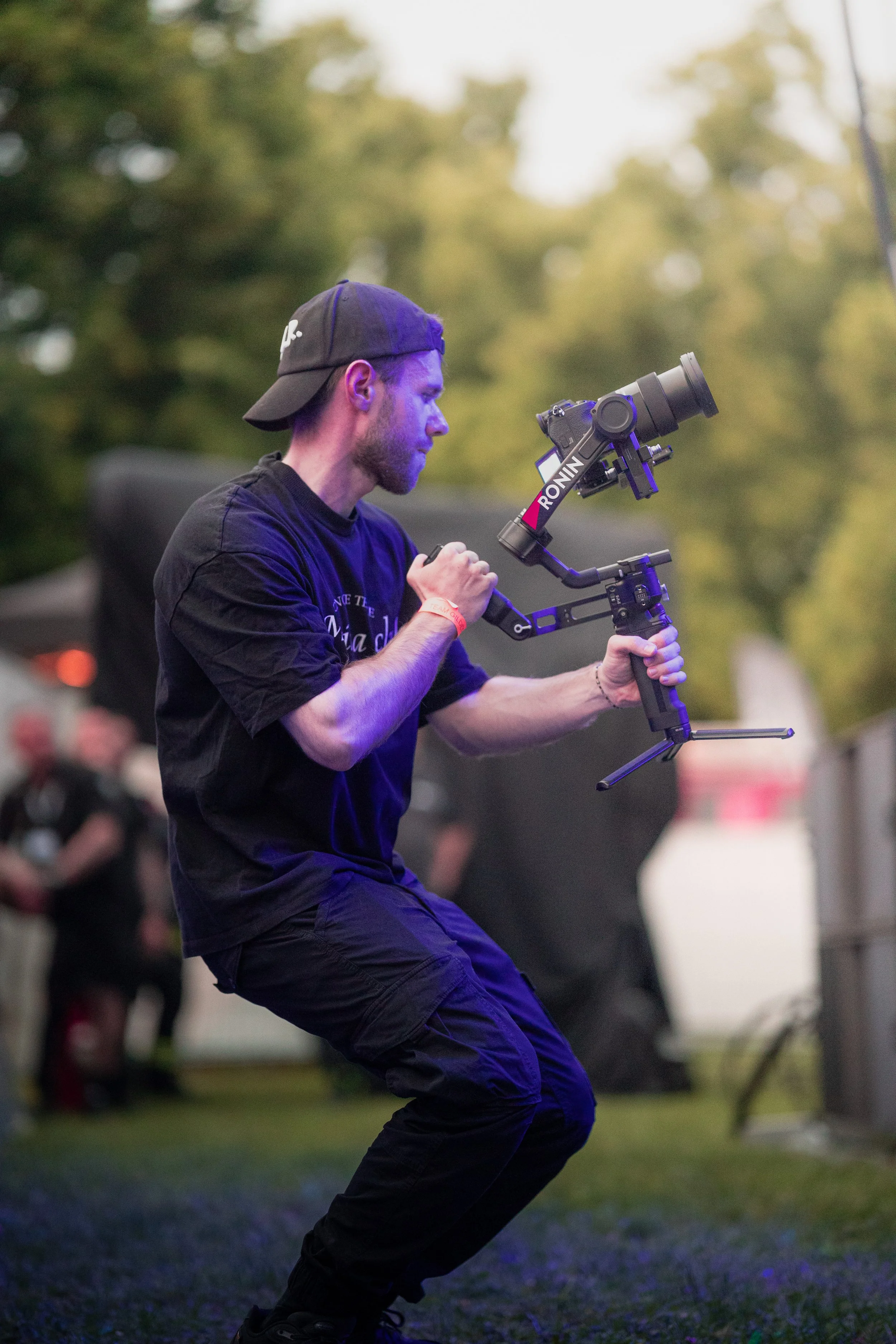 Mann filmt mit einer stabilisierten Kamera an einer Fotostation im Freien bei Dämmerung