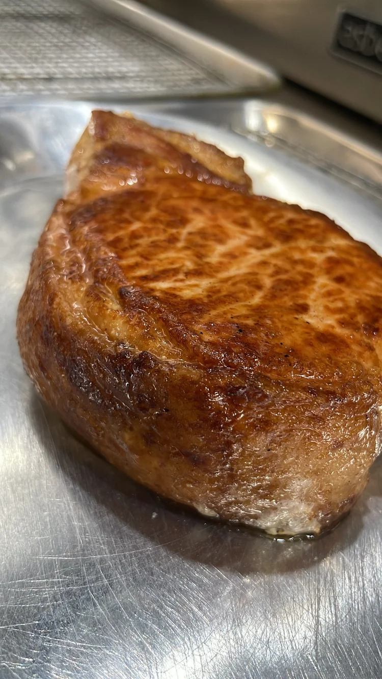Seasoned steak on steel surface
