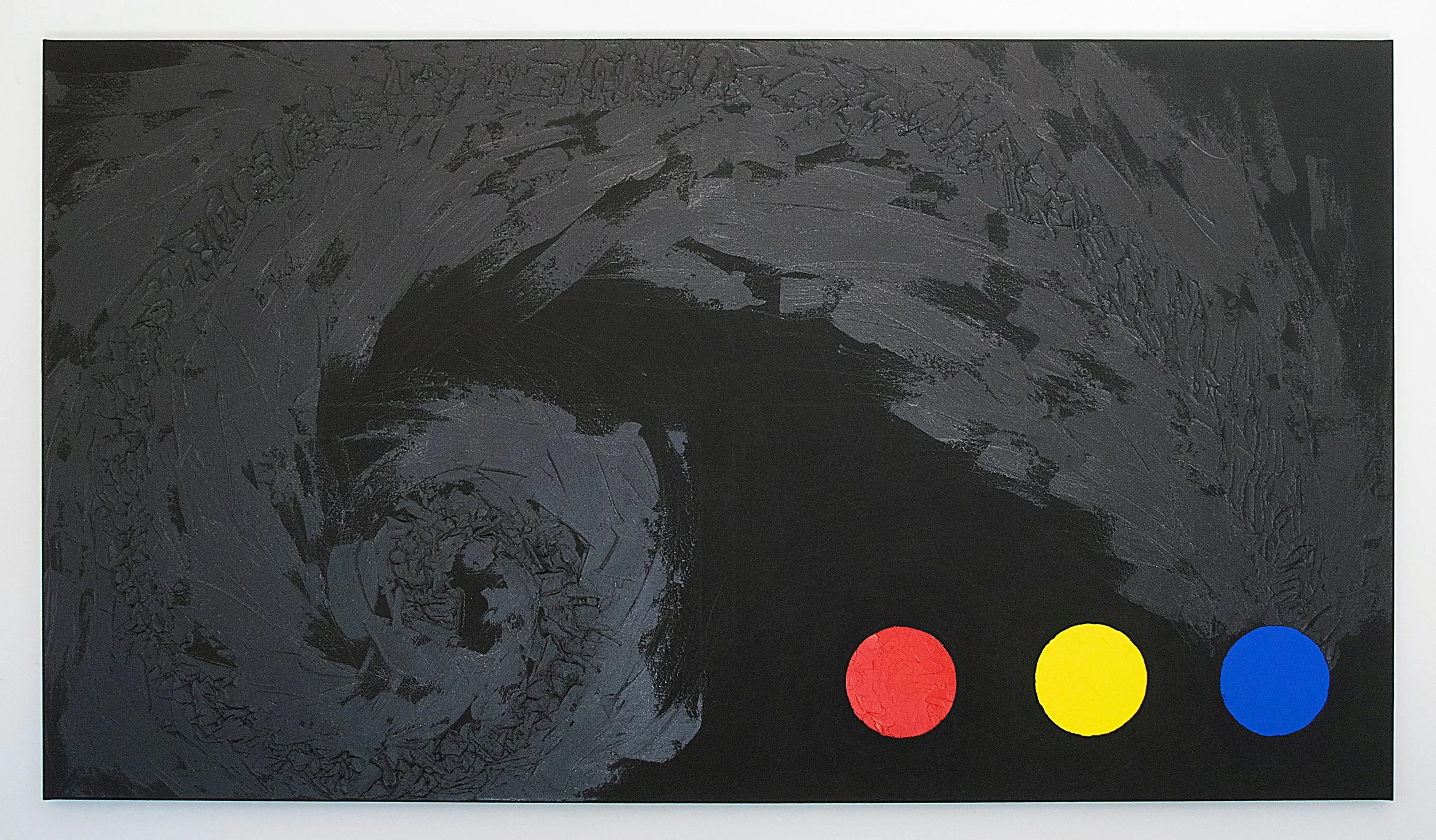 Schwarz bemaltes Kunstwerk mit drei farbigen Kreisen vorne: rot, gelb, blau.